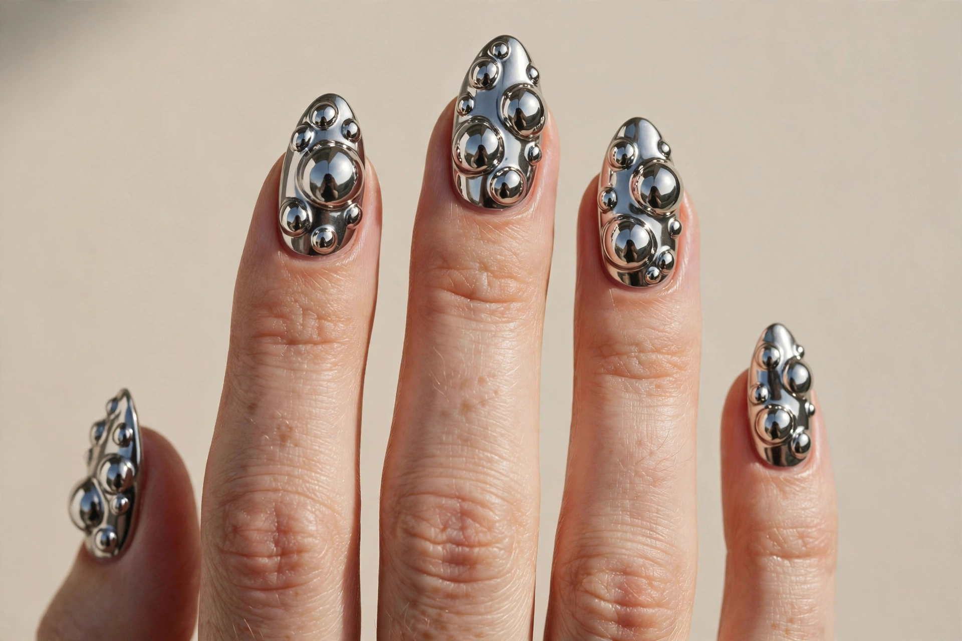 3D chrome bubble nail art with raised liquid-metal blobs in mirror finish