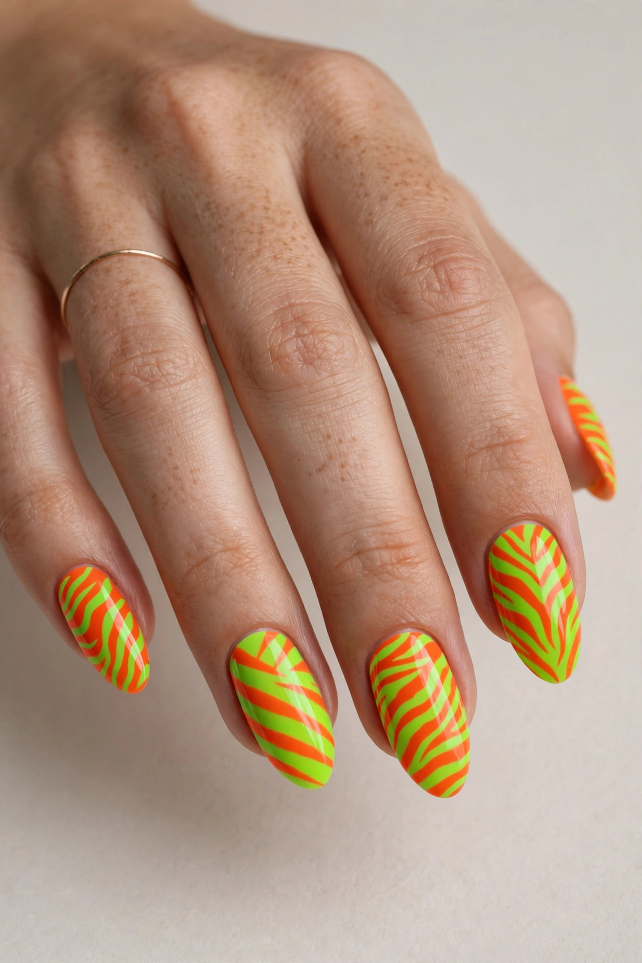 Neon animal print nails with lime green and orange zebra stripes
