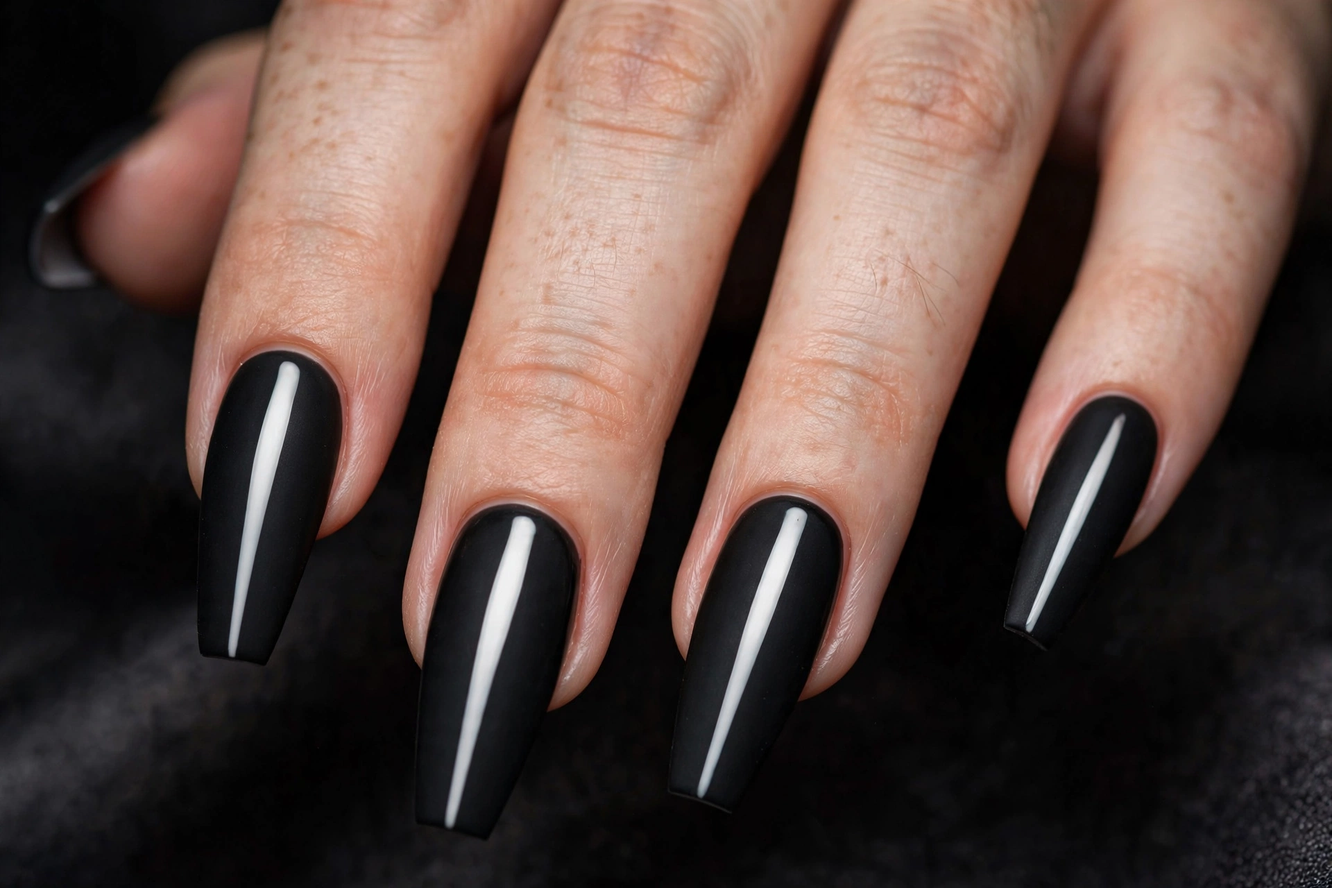 Long matte black coffin nails with a single bold glossy white vertical stripe down the center