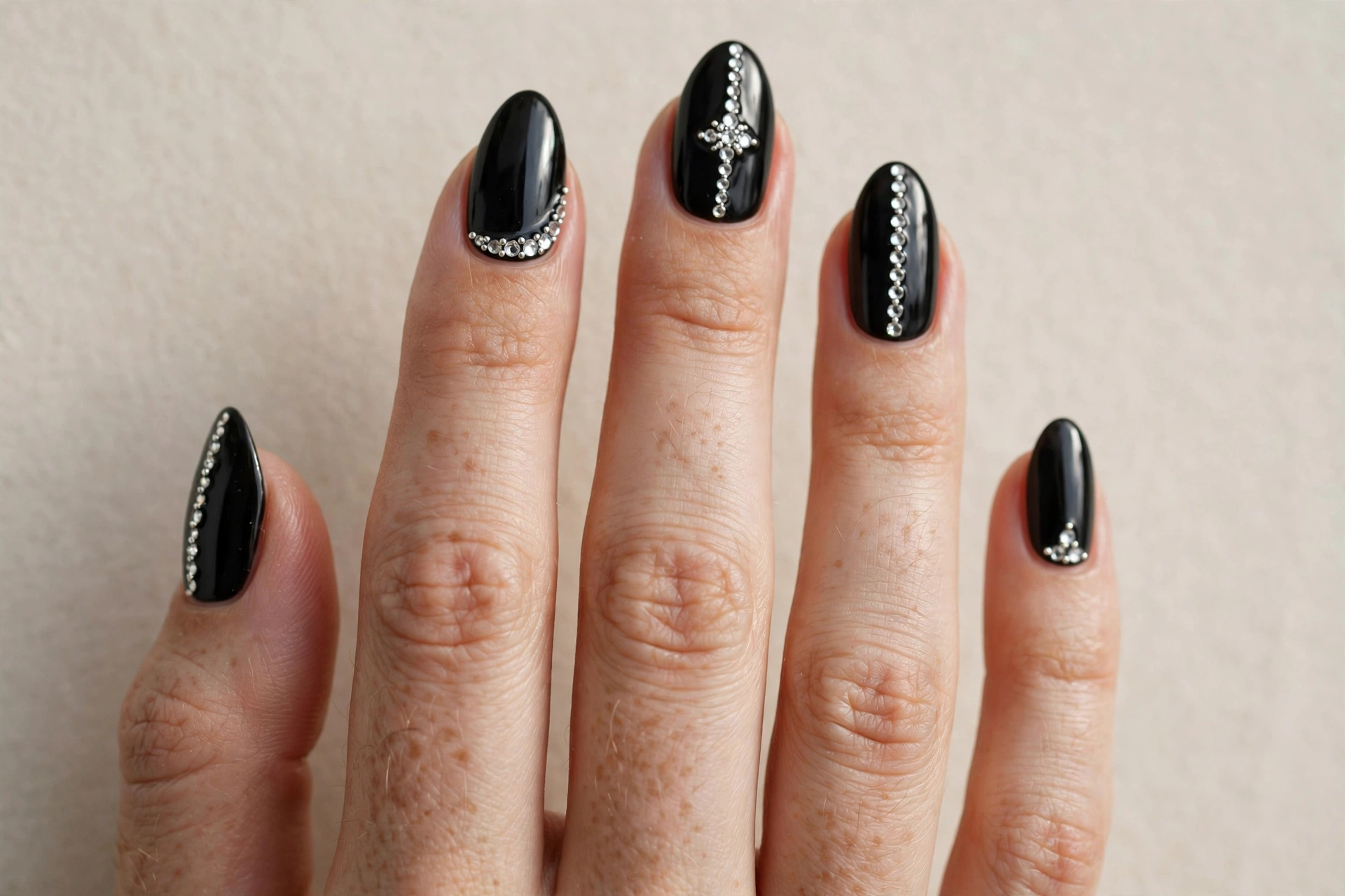 Black nails decorated with silver rhinestones