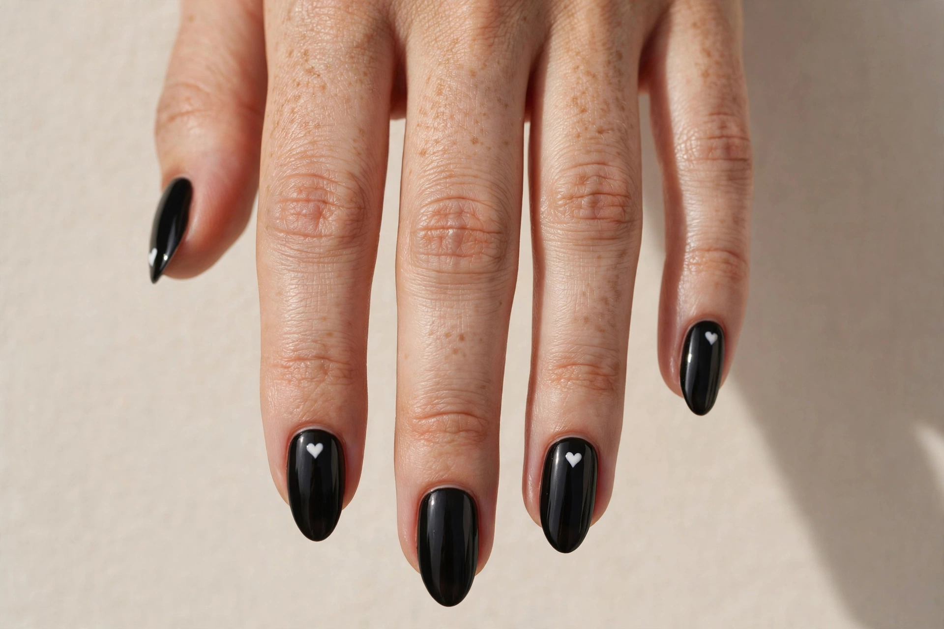 Black nails with small white heart accents