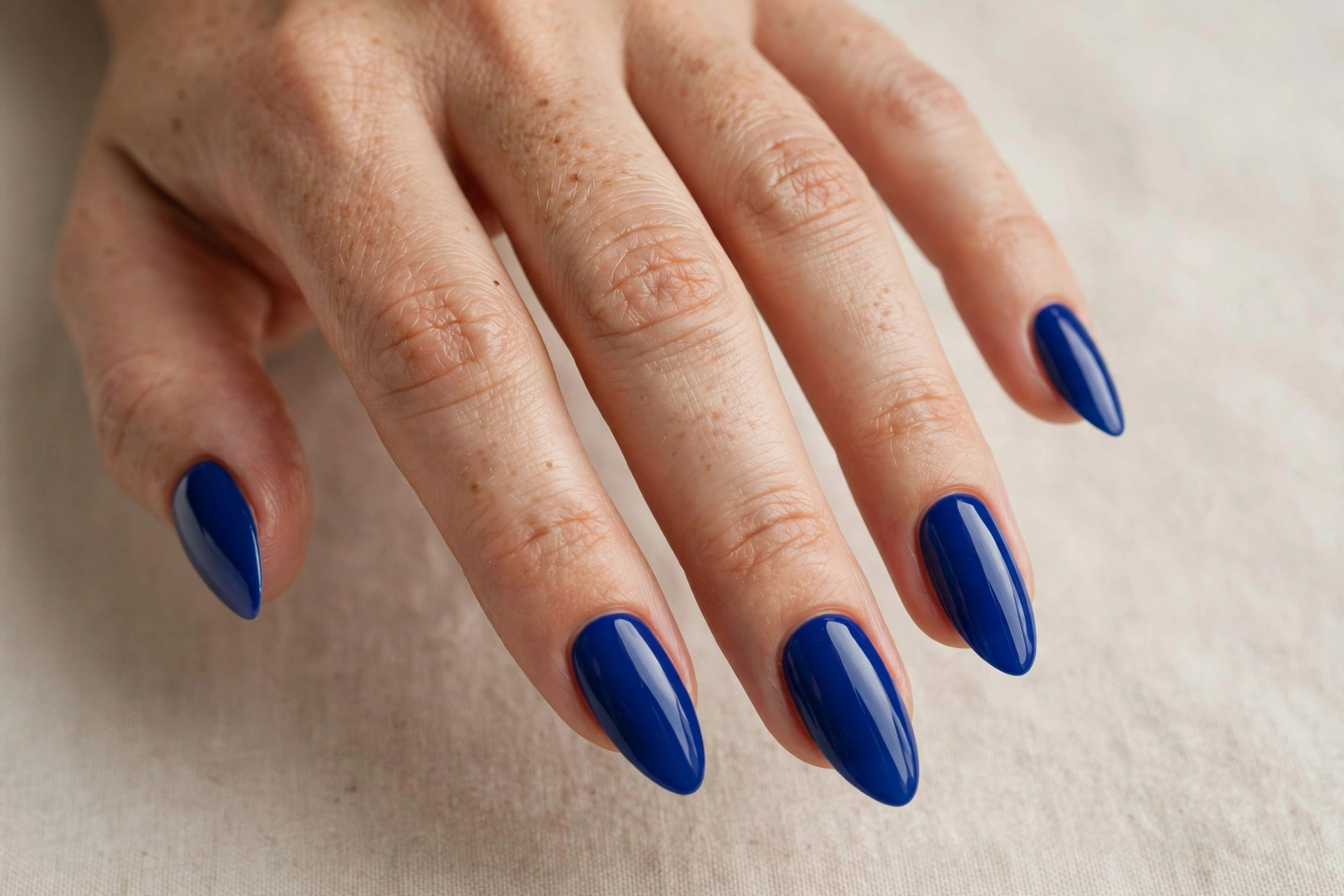 Classic royal blue solid nail polish on almond shaped nails