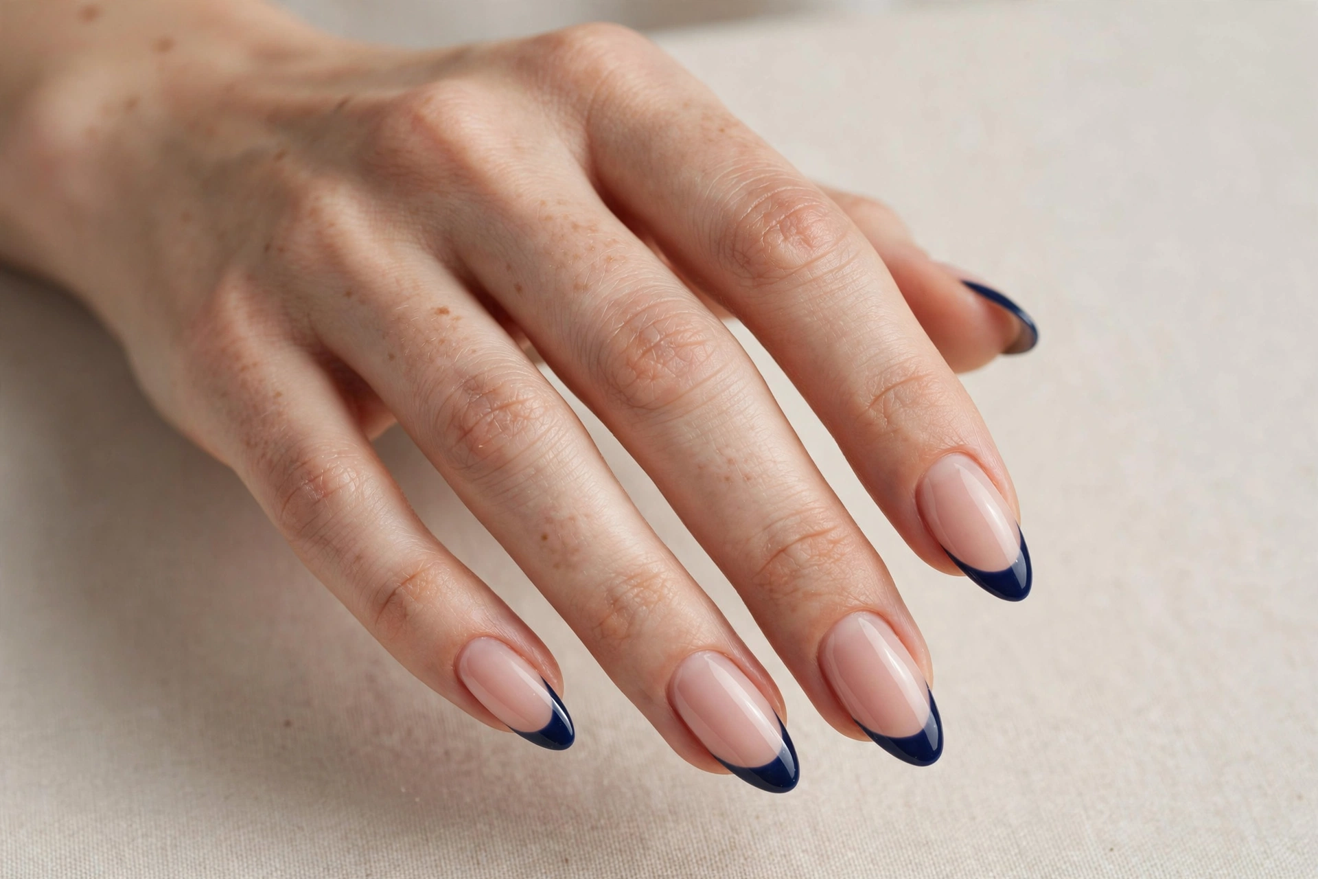 Navy blue French tip nail art on a nude base