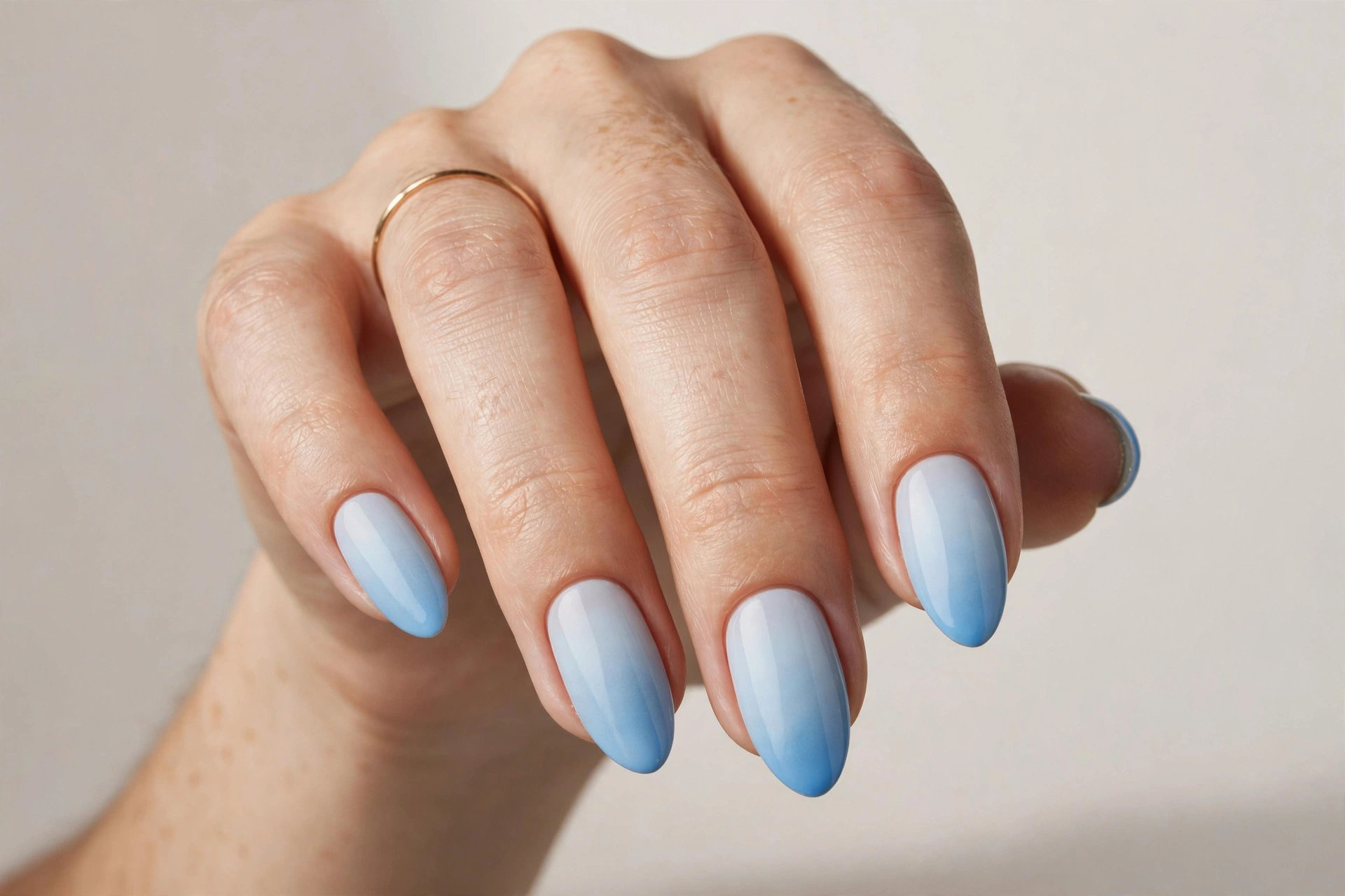 Light blue ombre gradient nail art fading from white to sky blue