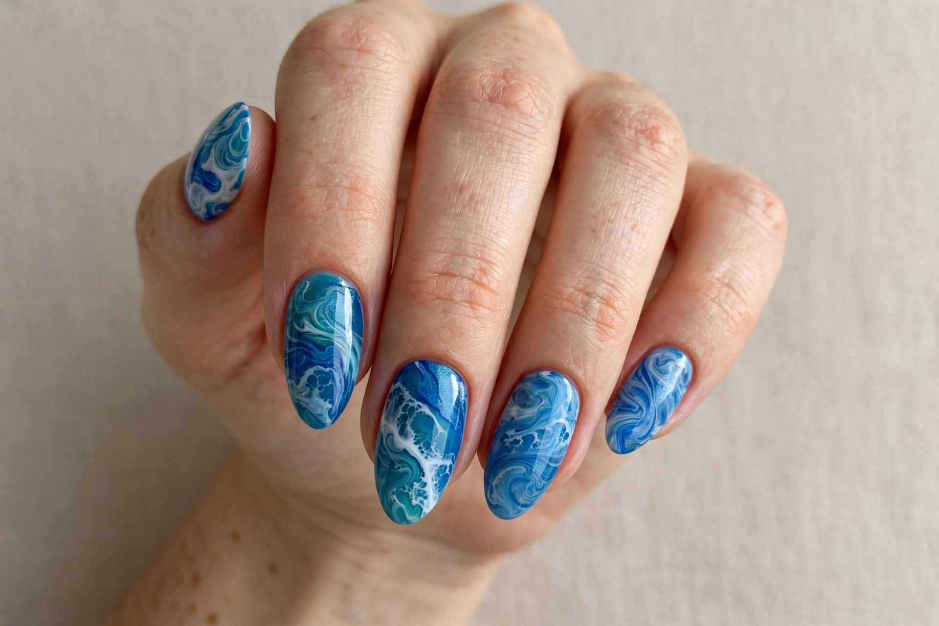 Ocean waves blue marble nail art with swirling blue tones