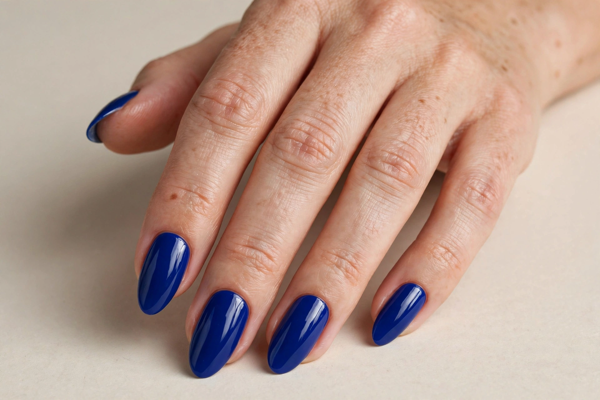 Classic solid cobalt blue manicure with a glossy finish on almond shaped nails