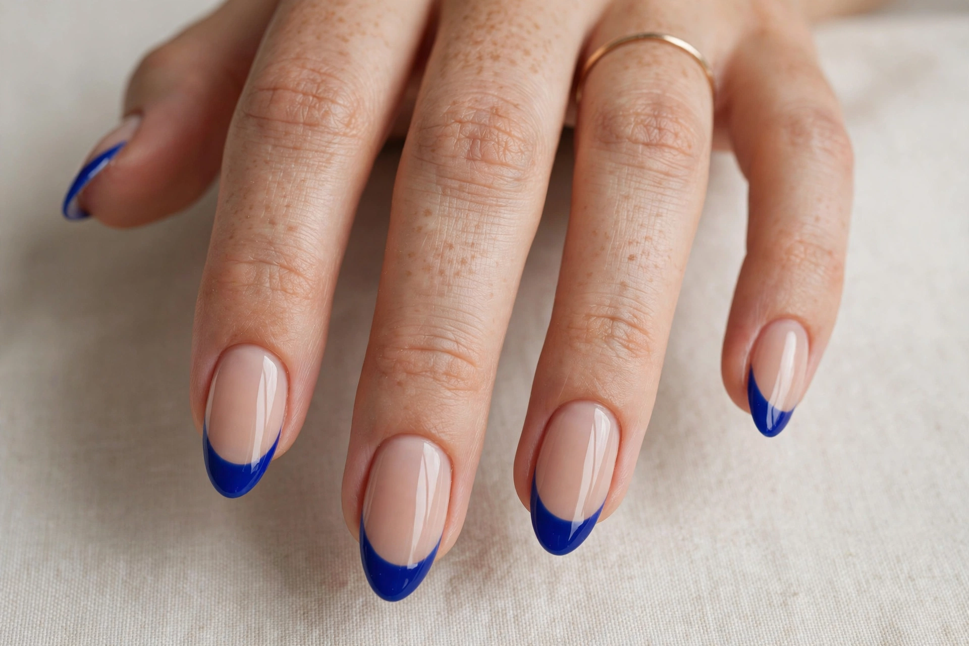 Royal blue french tip manicure on nude base nails, almond shape