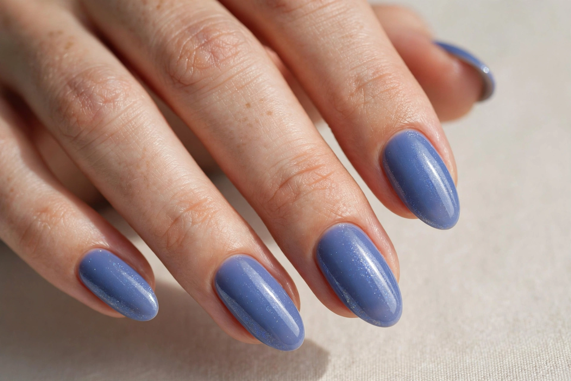 Periwinkle blue glossy manicure with soft shimmer on almond nails