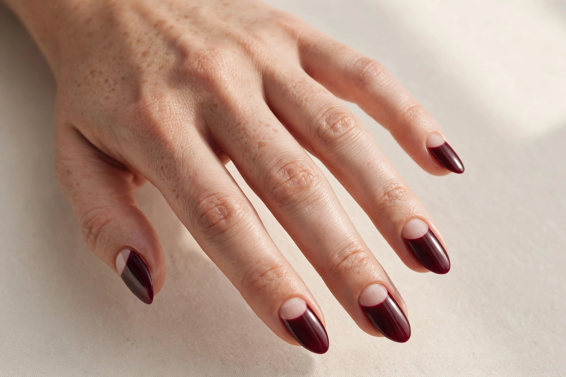Burgundy French tip nails with deep wine tips on a natural nude base