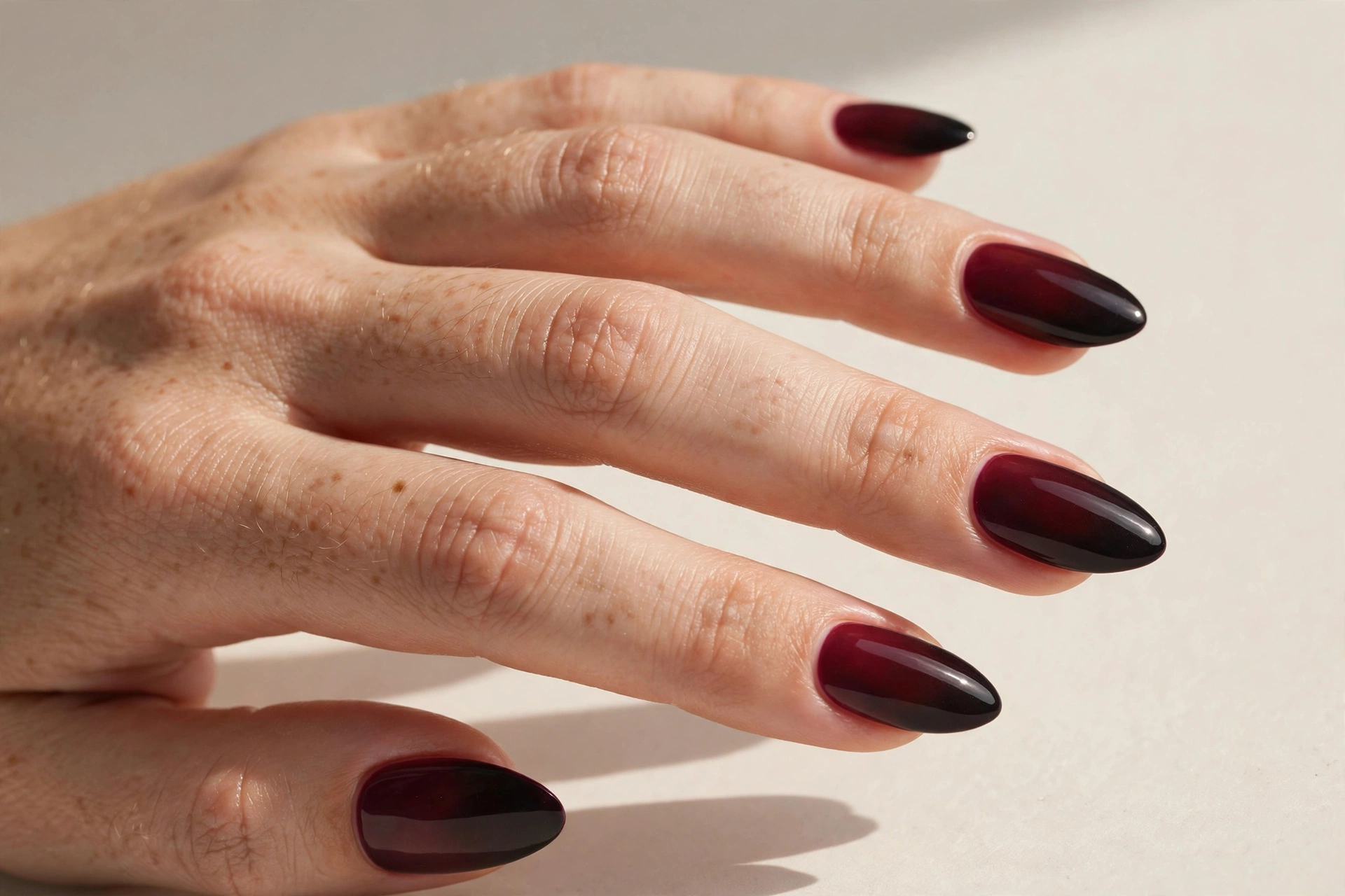 Burgundy to black ombre gradient nails on long almond shaped nails