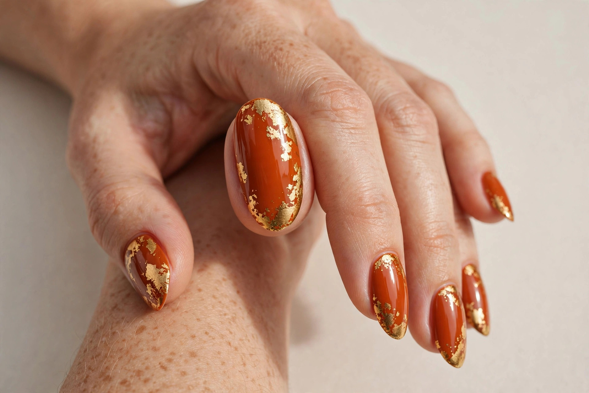 Burnt orange nails with gold foil accents
