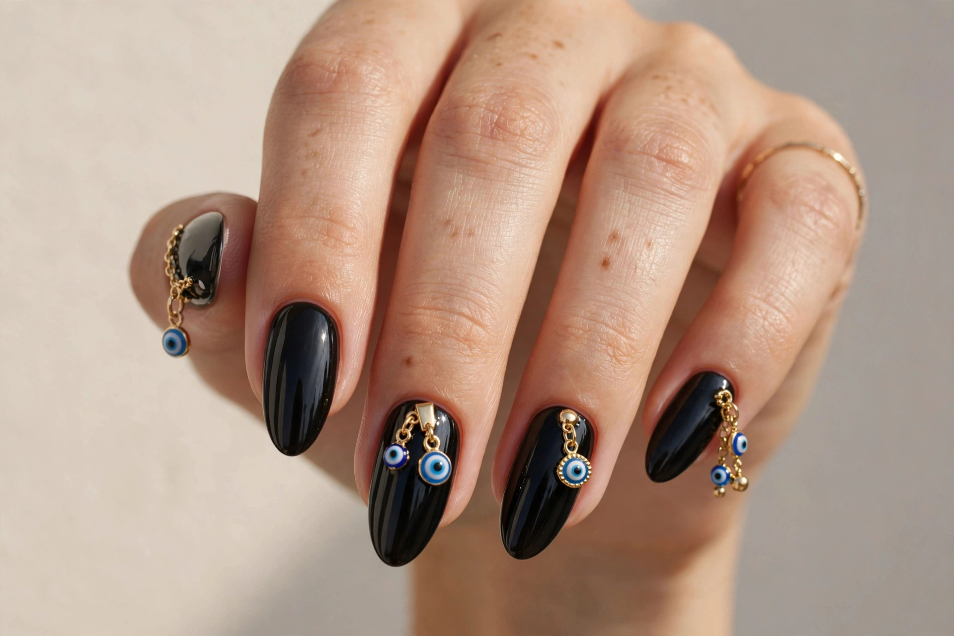 Glossy black almond nails with evil eye protection charms