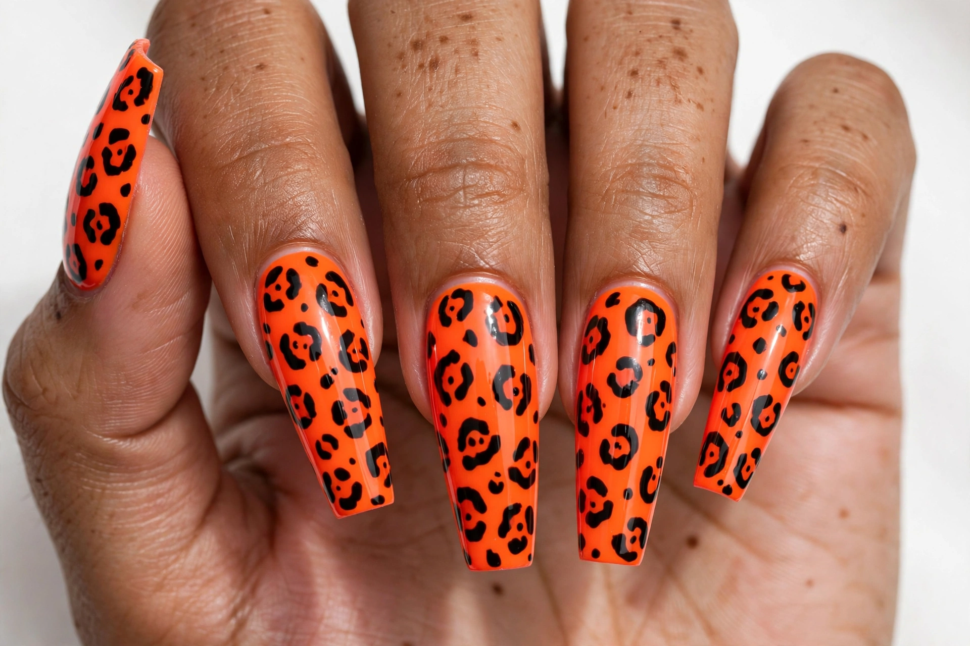 Neon orange cheetah print nail art on coffin nails
