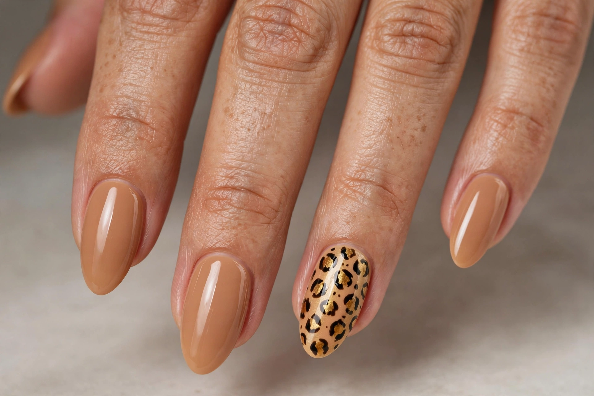 Solid nude manicure with one cheetah print accent nail