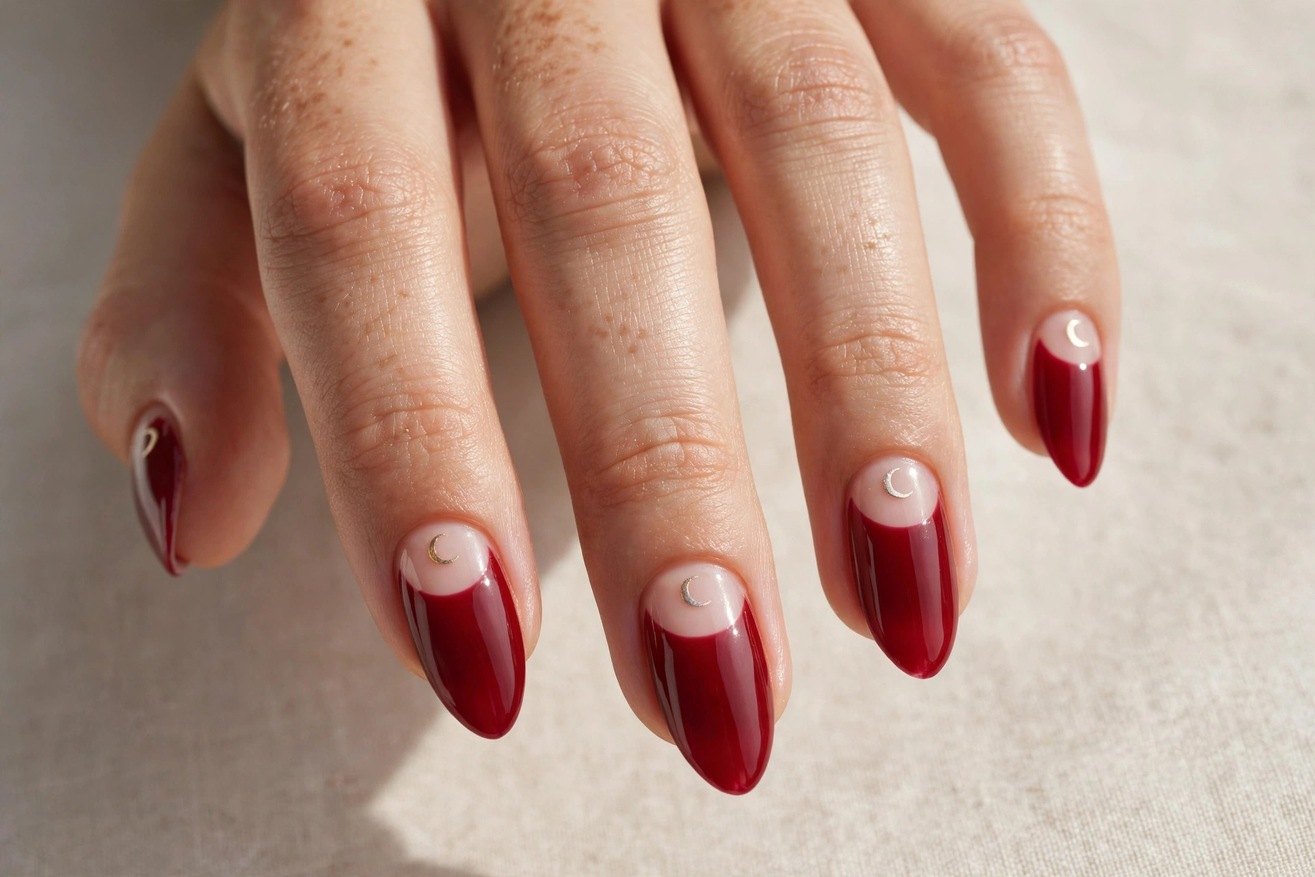Cherry reverse French moon manicure with crescents at the cuticle
