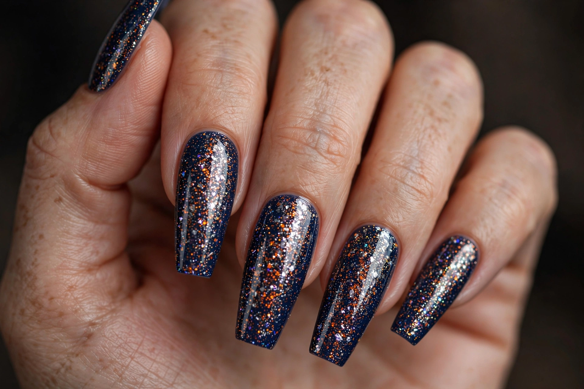 Coffin shaped nails with navy base and silver orange holographic glitter