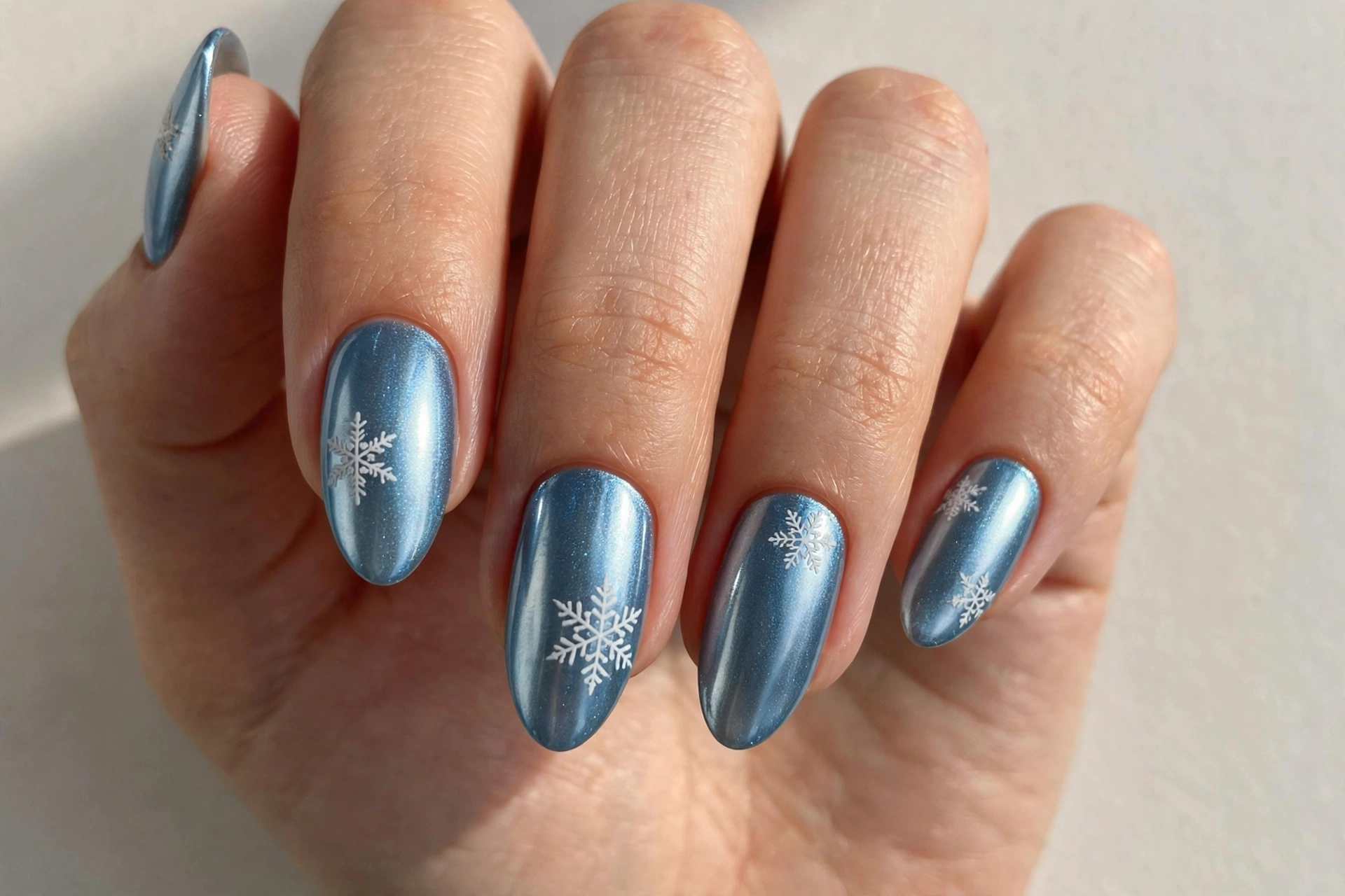Icy blue chrome press-on nails with snowflake decals for Christmas