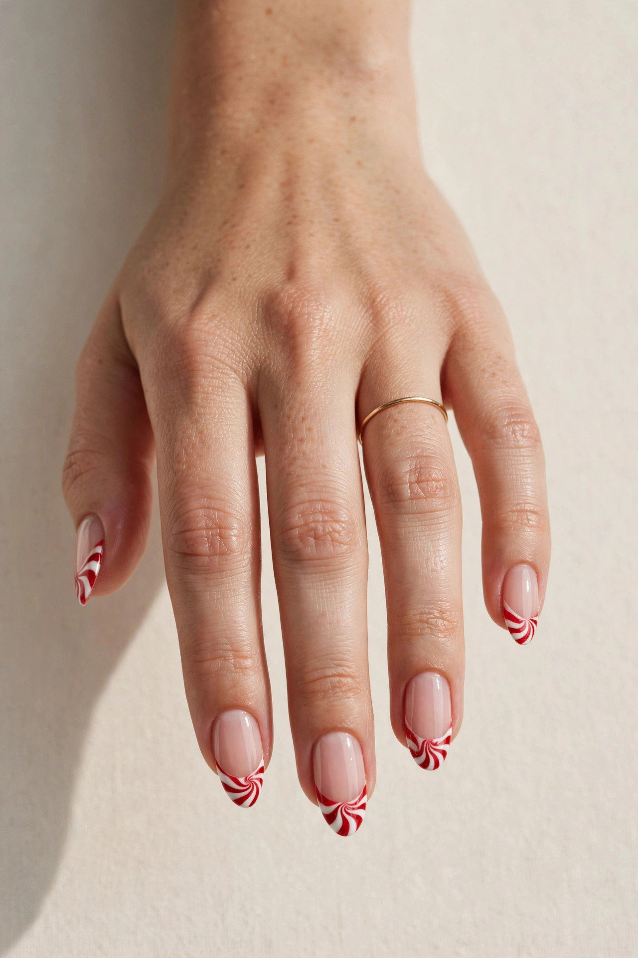 Red and white peppermint swirl French tip Christmas nails