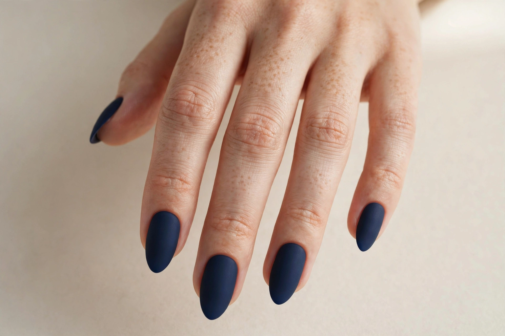 Matte deep navy blue manicure with a velvety finish