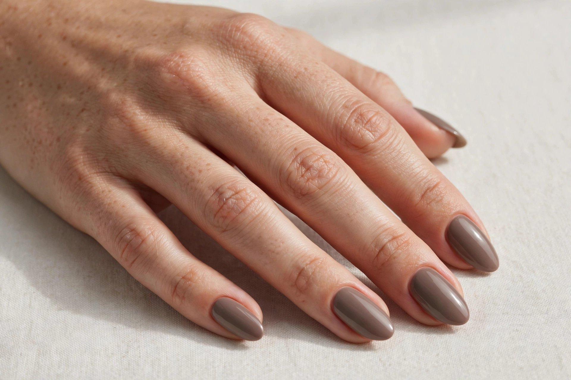 Taupe solid color manicure with a smooth glossy finish