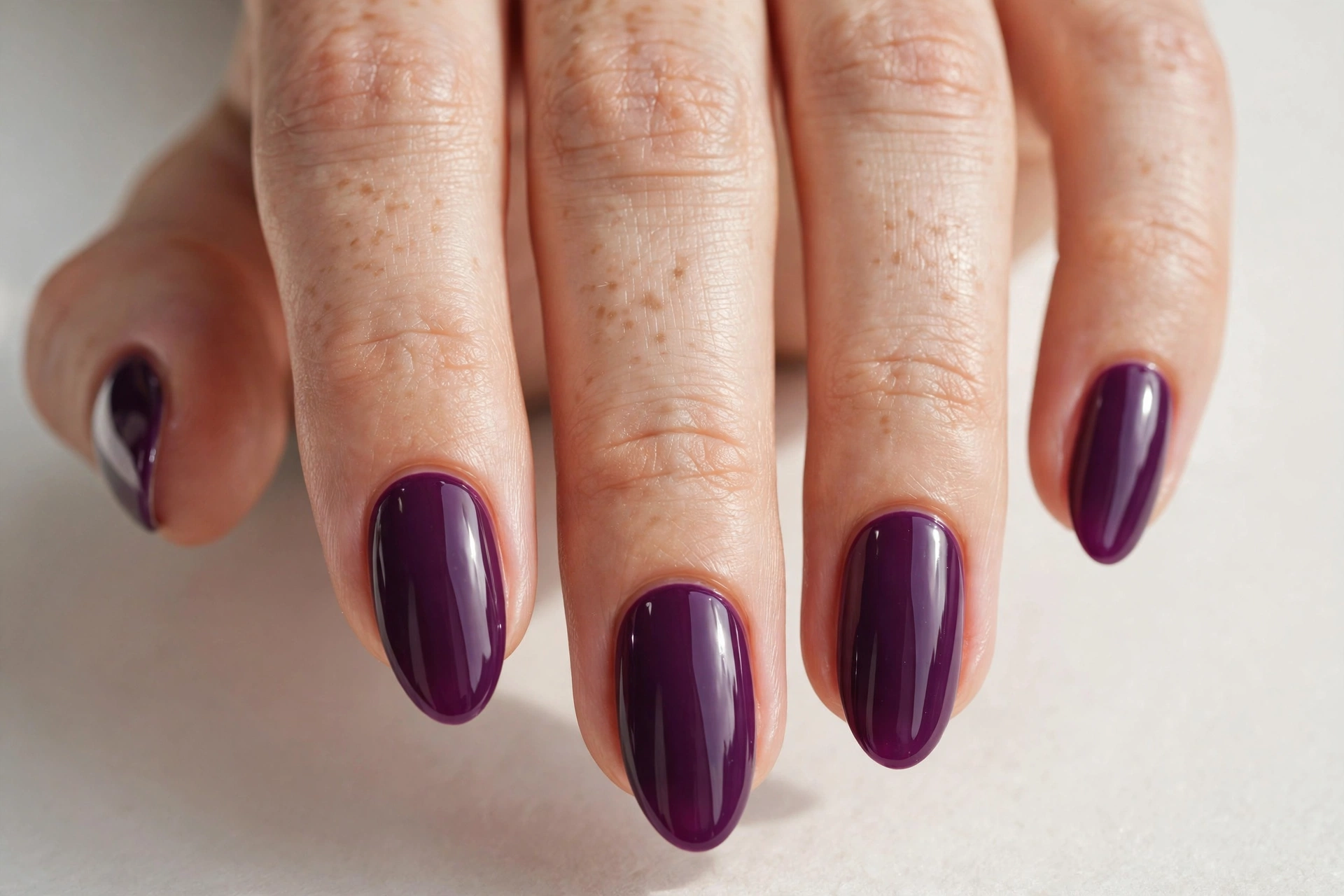 Plum purple manicure with a high-gloss shiny finish