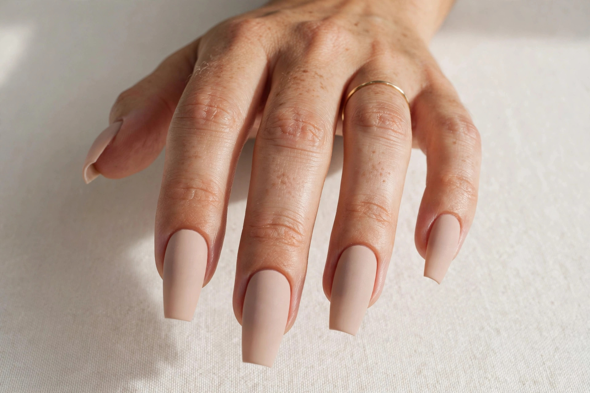 Close-up of nude matte coffin shaped nails