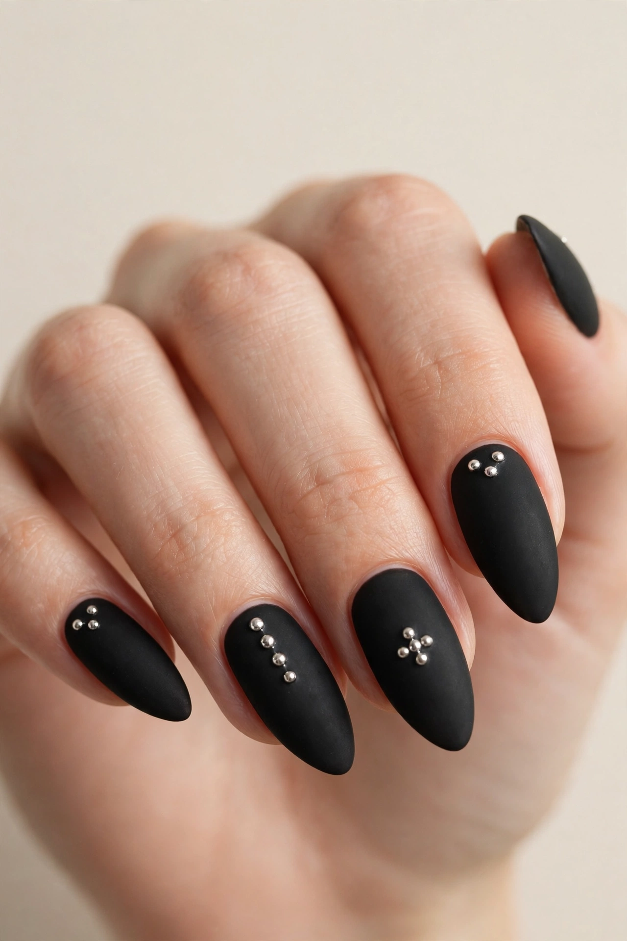 Matte black cool nail design with silver stud accents