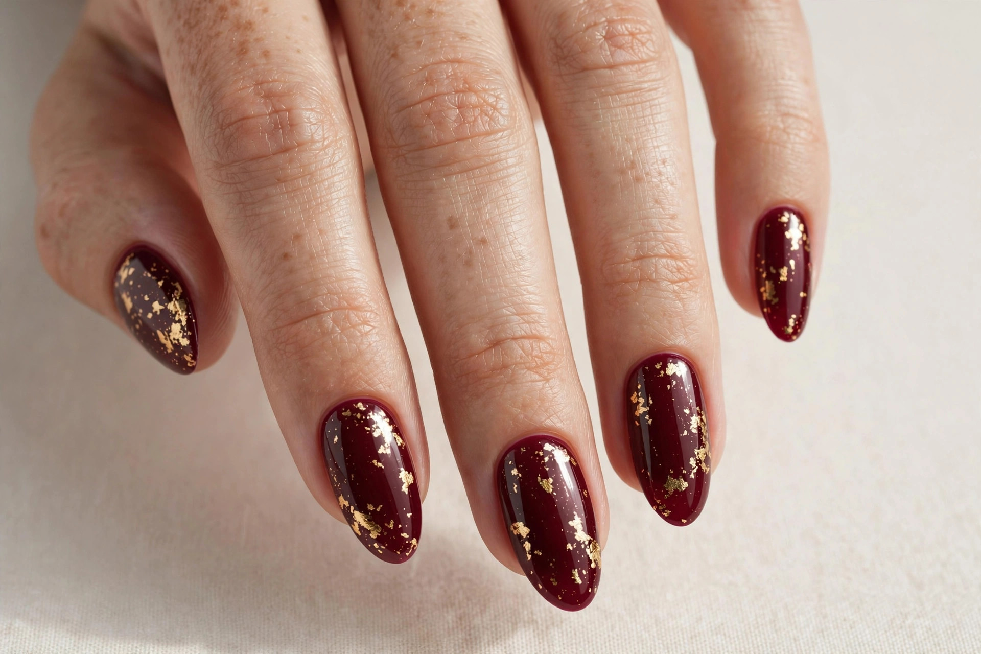 Cranberry wine nails with gold foil flakes