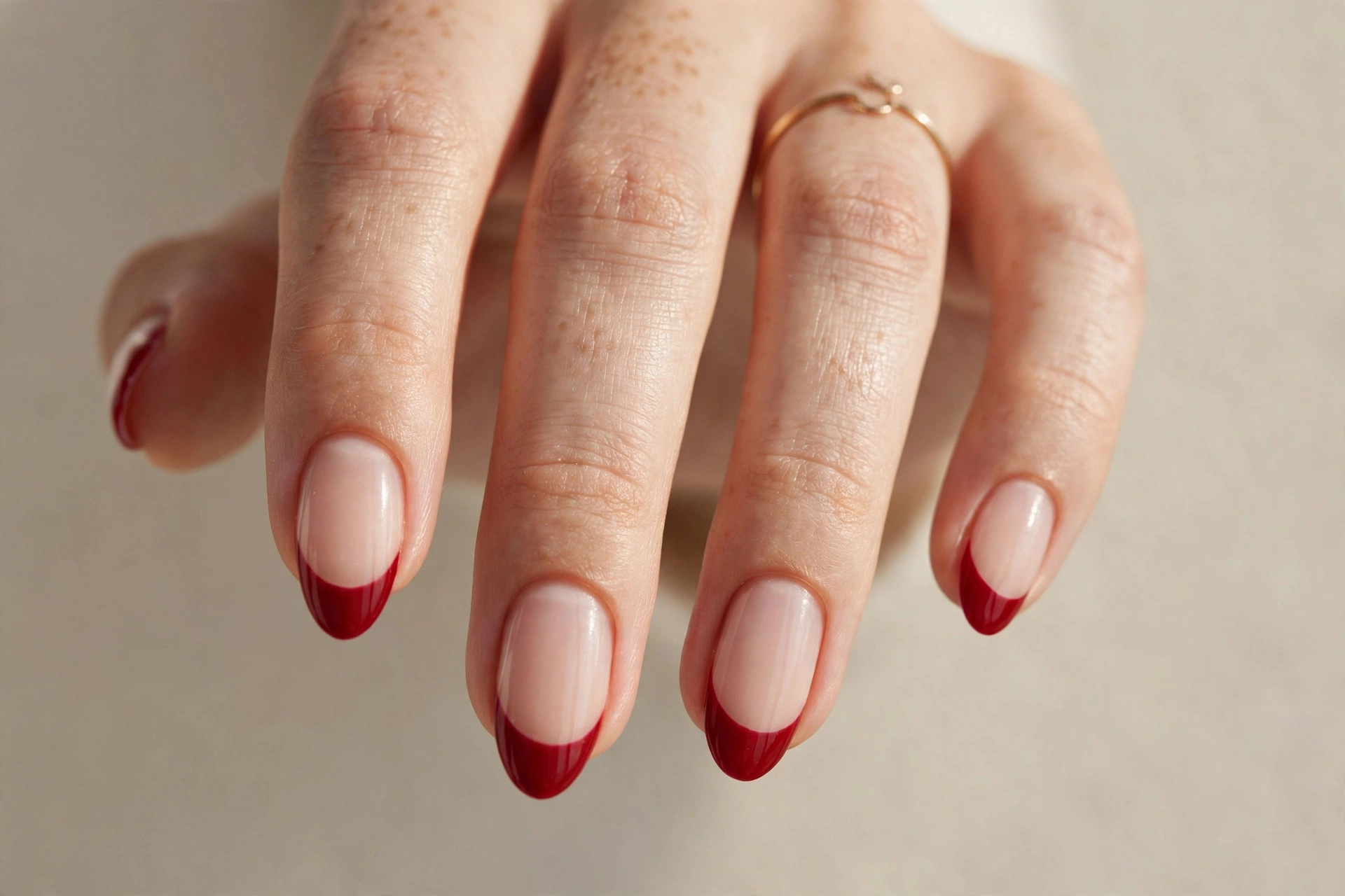 Red French tip manicure on almond shaped nails