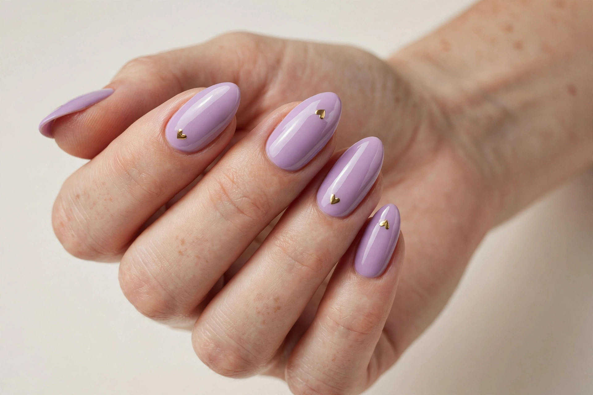 Lilac manicure with tiny gold heart nail art