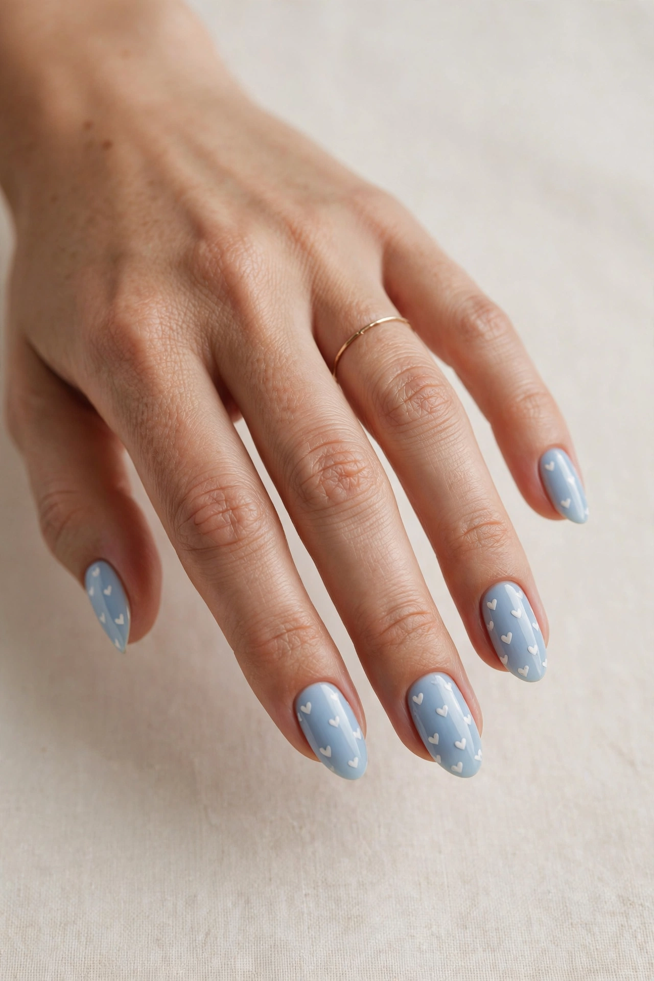 Baby blue base with tiny white hearts on short nails