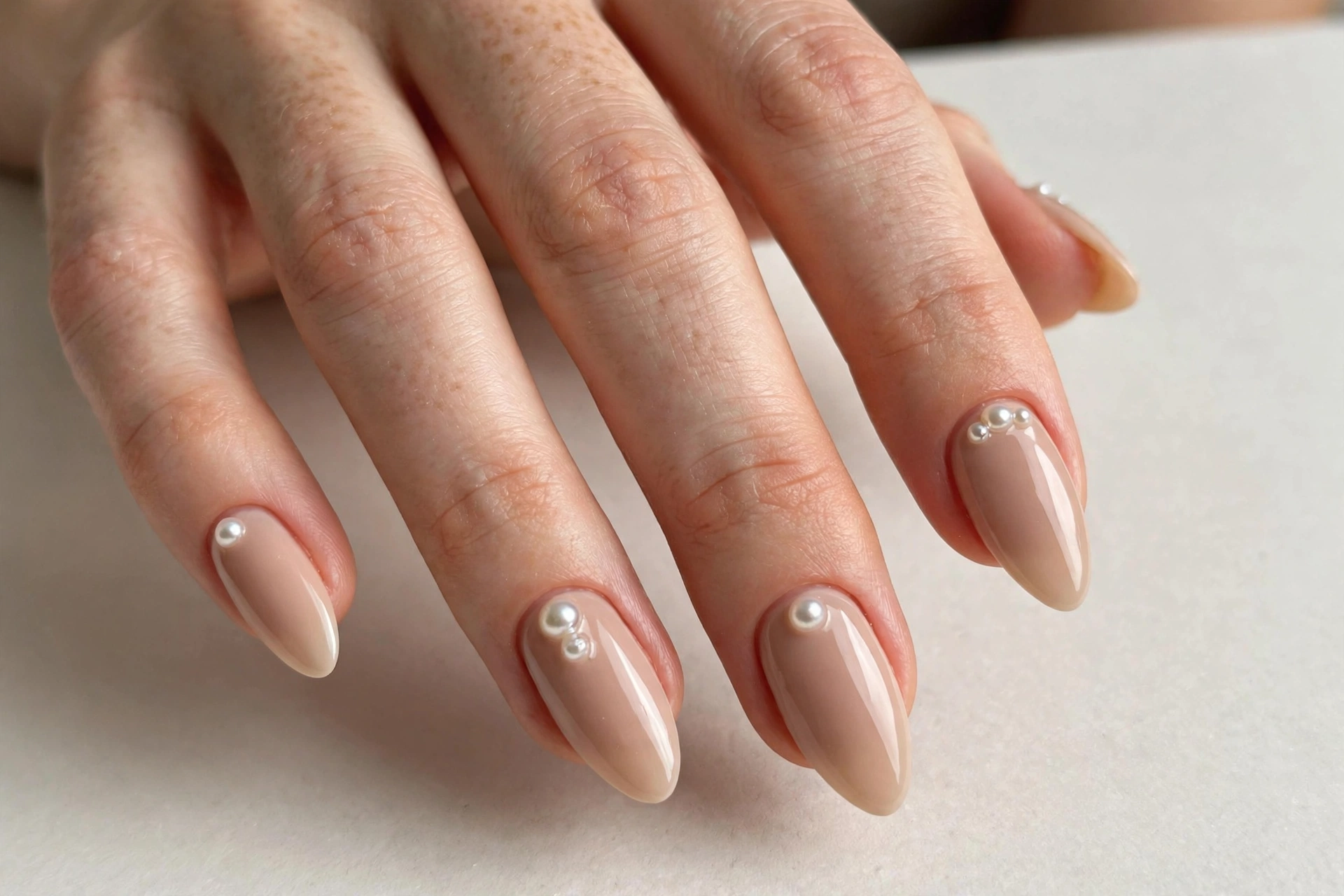 Nude manicure with pearl accents near the cuticles