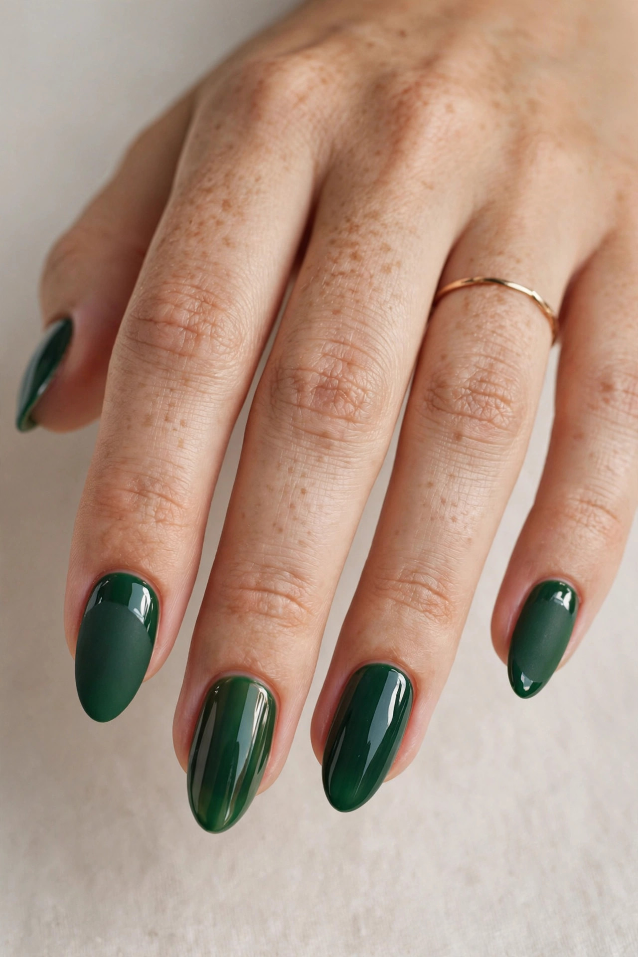 Close-up of a woman's hand with matte forest green nails