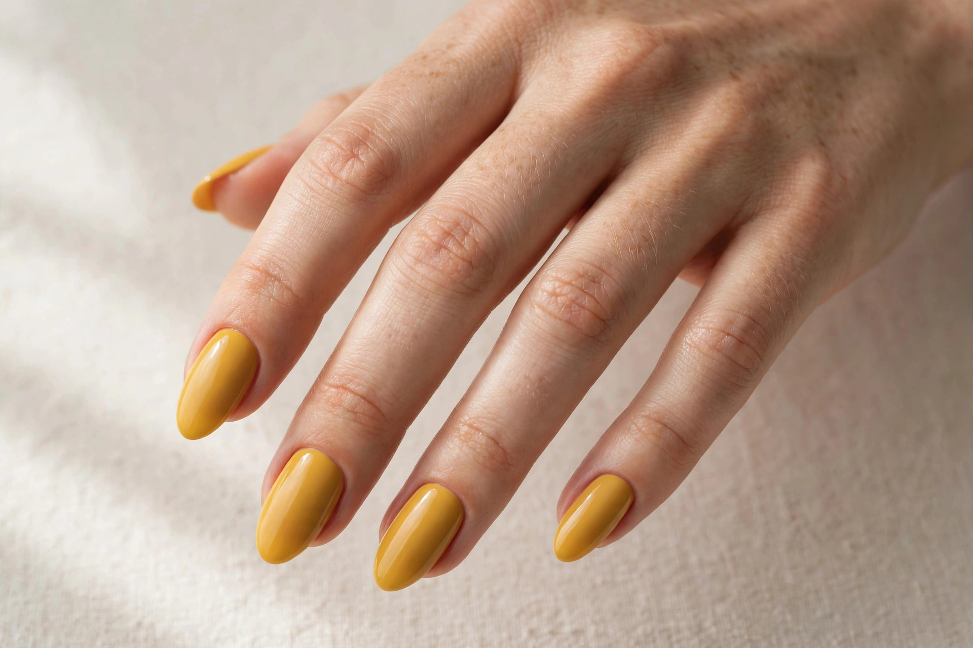 Mustard yellow solid color manicure on almond shaped nails