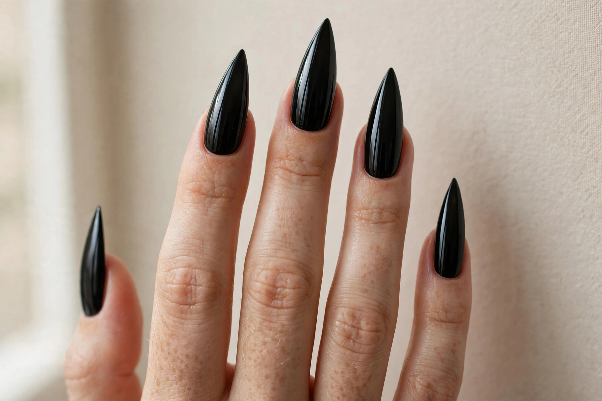 Glossy black stiletto nails with a mirror shine