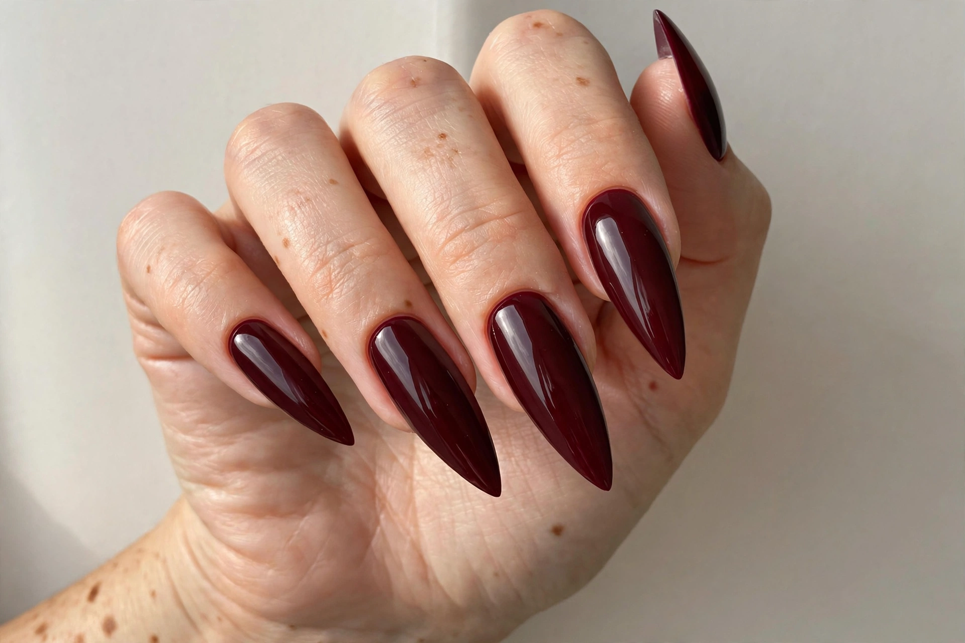 Deep burgundy stiletto nails with a glossy finish