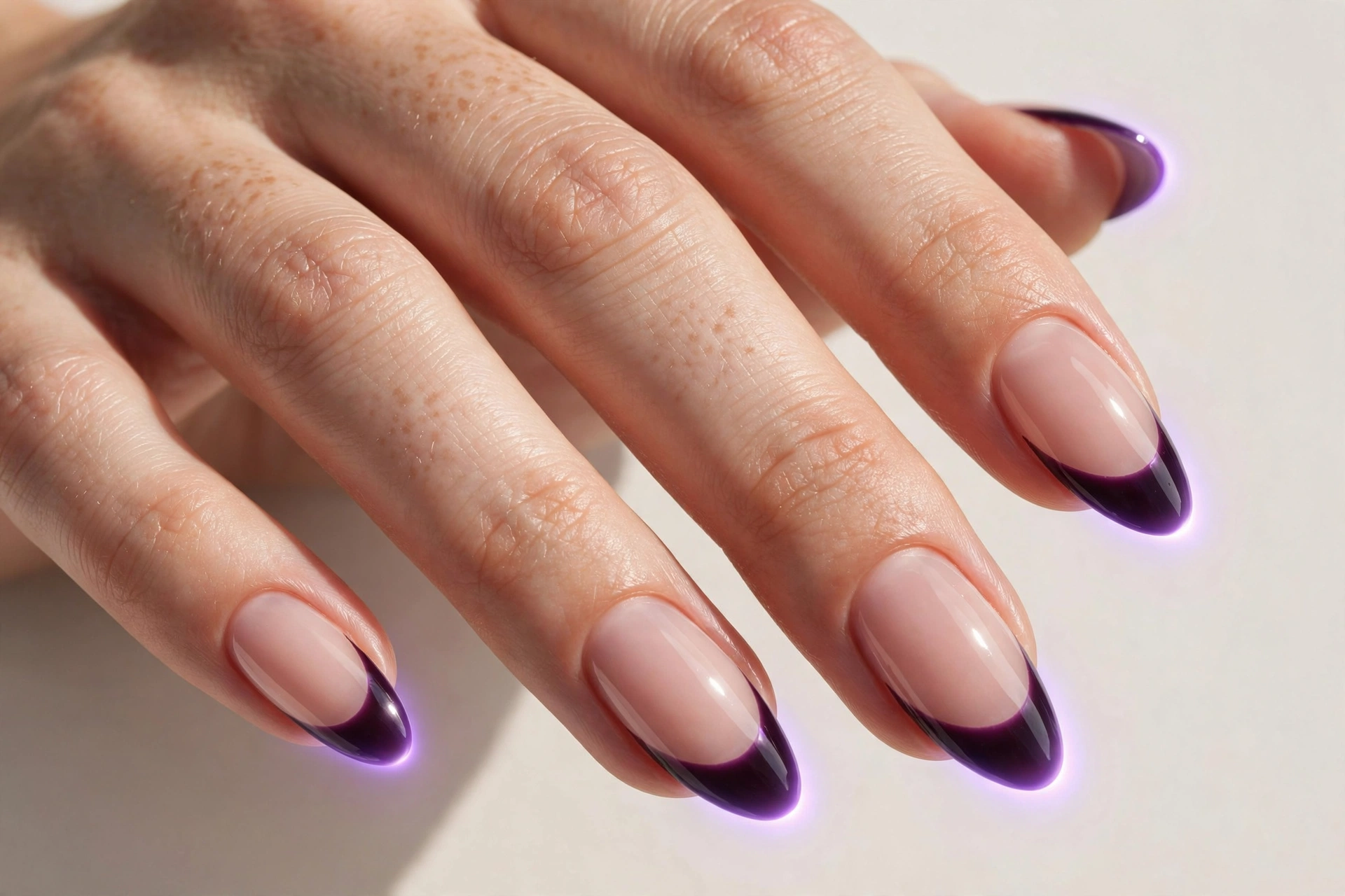 Midnight plum aura French tip nails with glowing plum tips over a sheer nude base