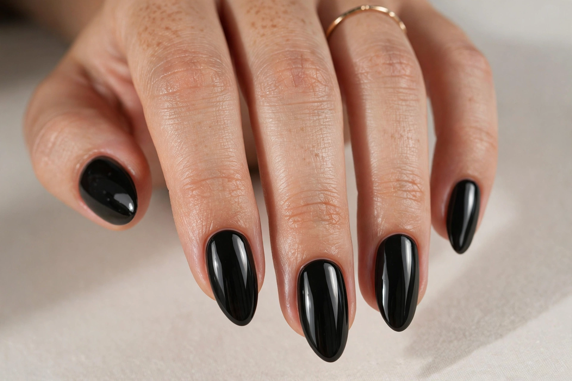 Glossy solid black manicure on almond nails