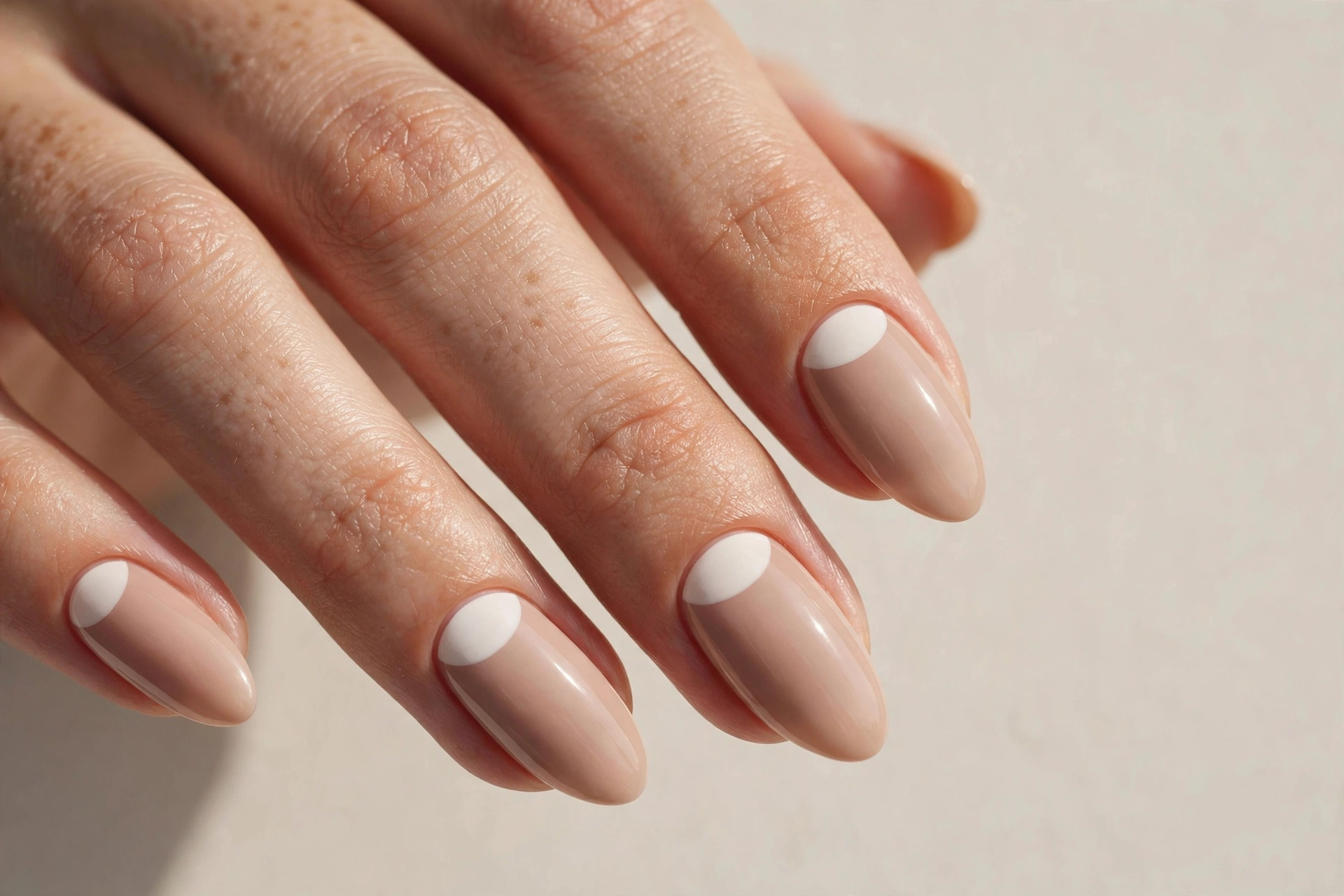White half moon manicure at the cuticle on nude nails