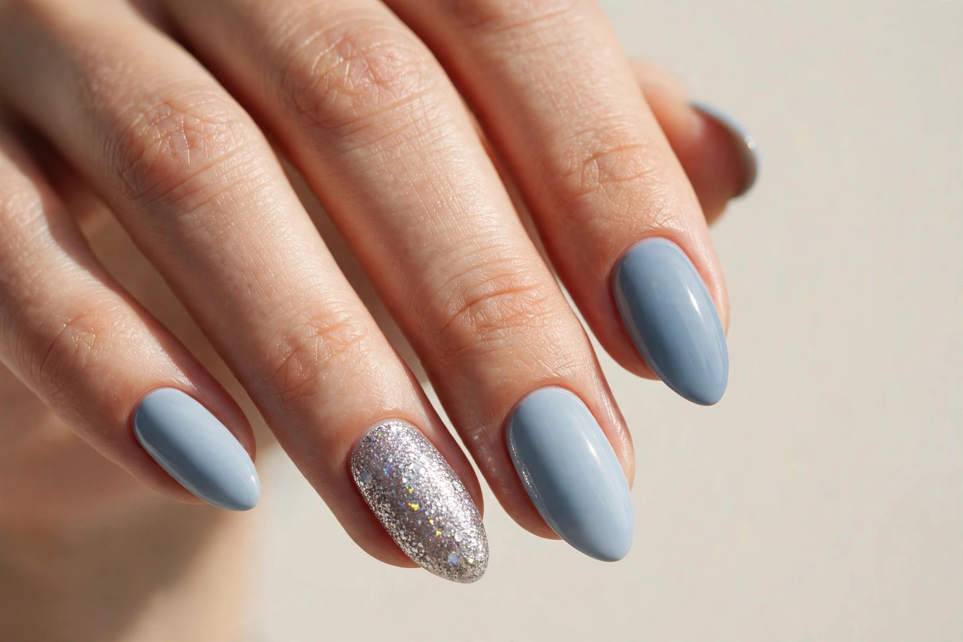 Silver glitter accent nail among soft blue nails