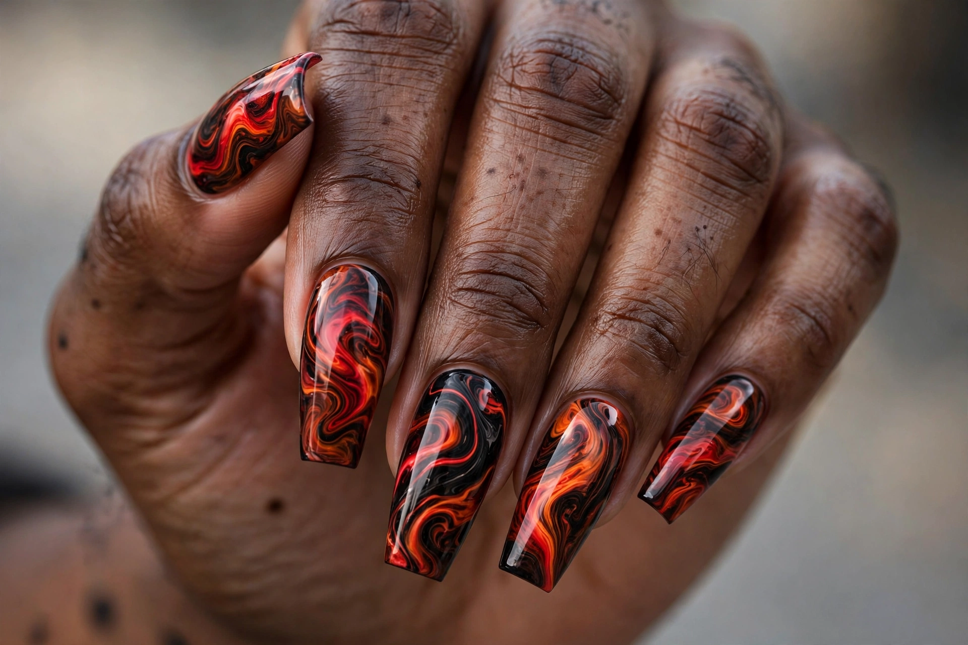 Coffin shaped nails with red and orange lava marble nail art