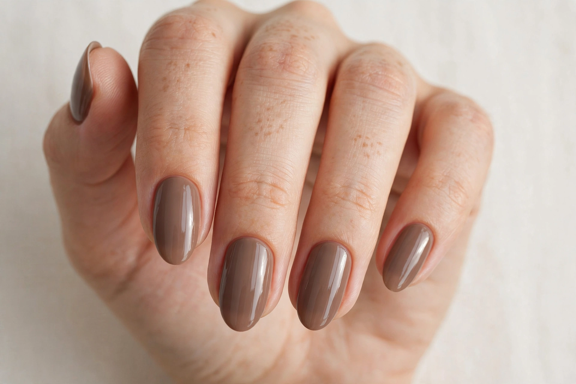 Warm taupe brown gel nail design with glossy finish