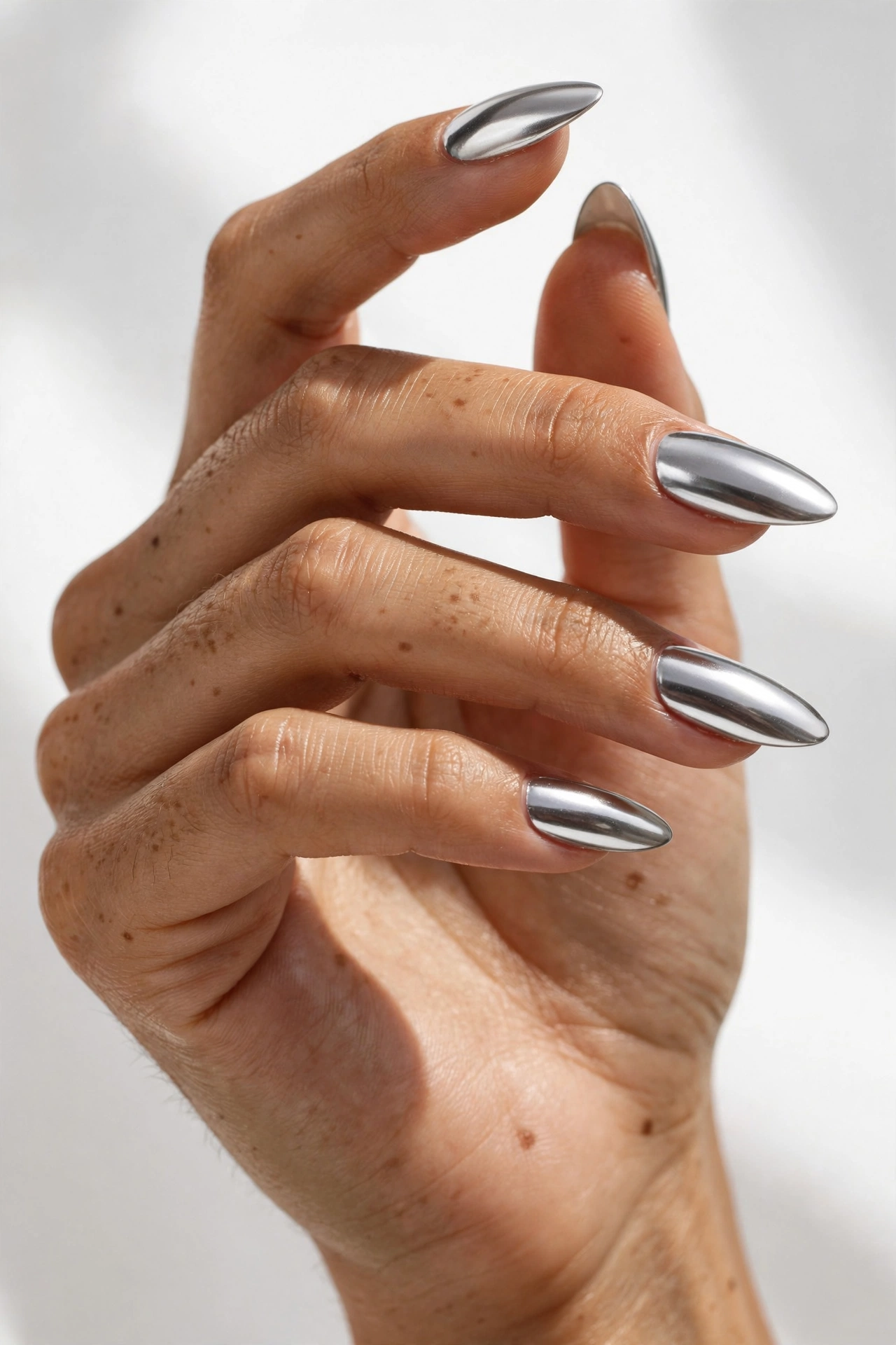 Mirror-like silver chrome on almond Gel X nail extensions