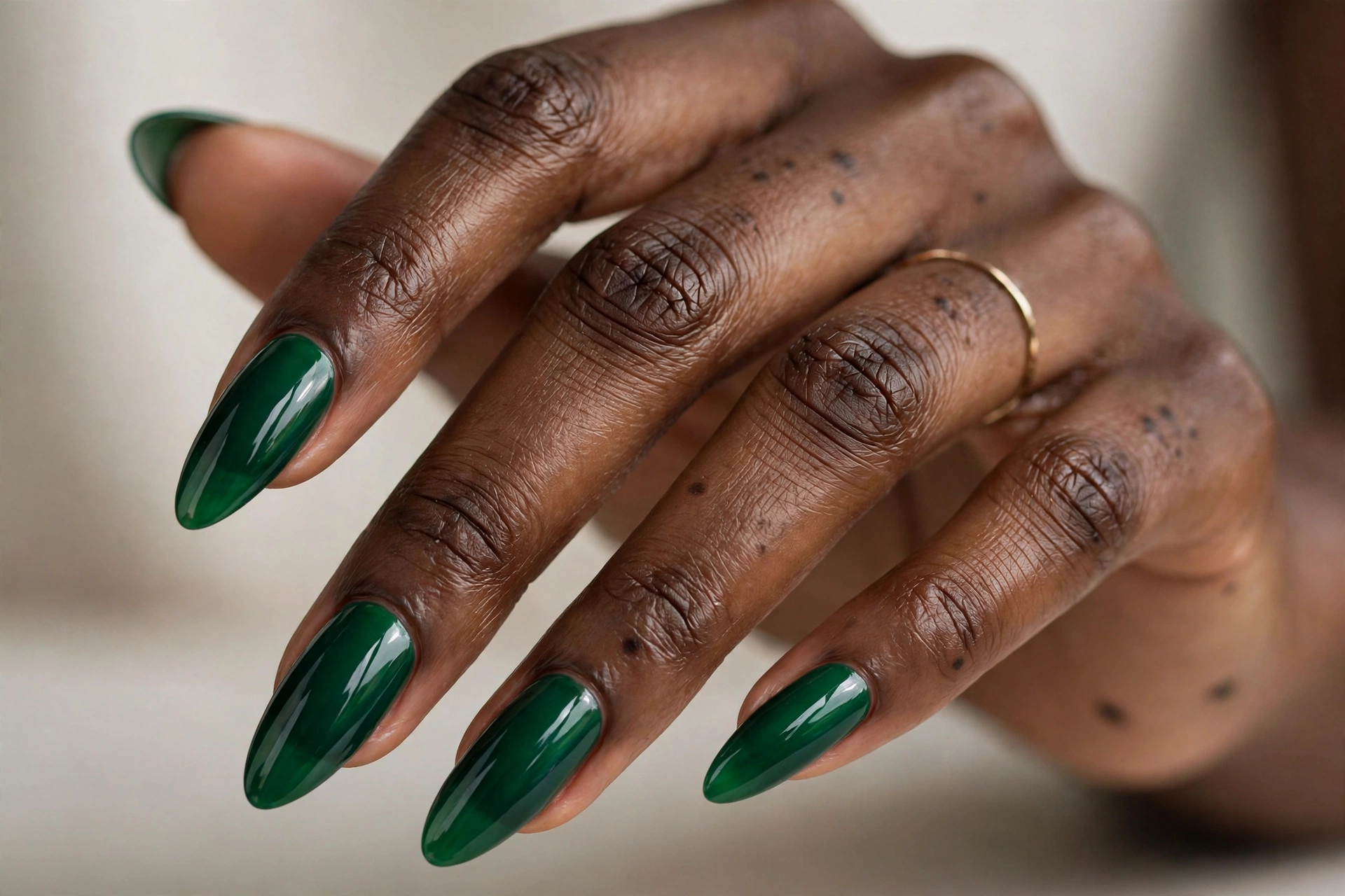 Rich glossy emerald green on almond Gel X nail extensions