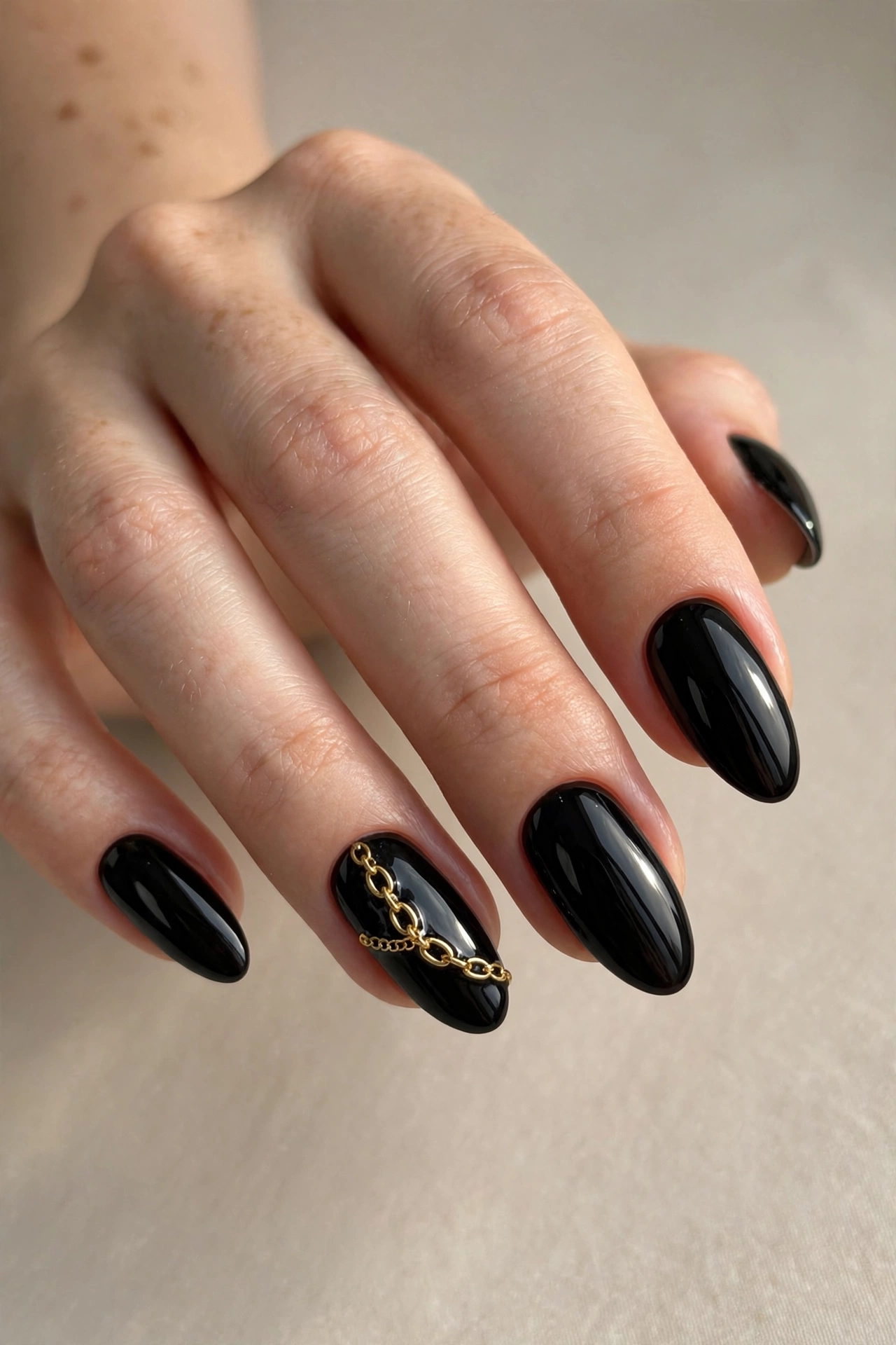 Delicate gold chain accent nail art on black nails