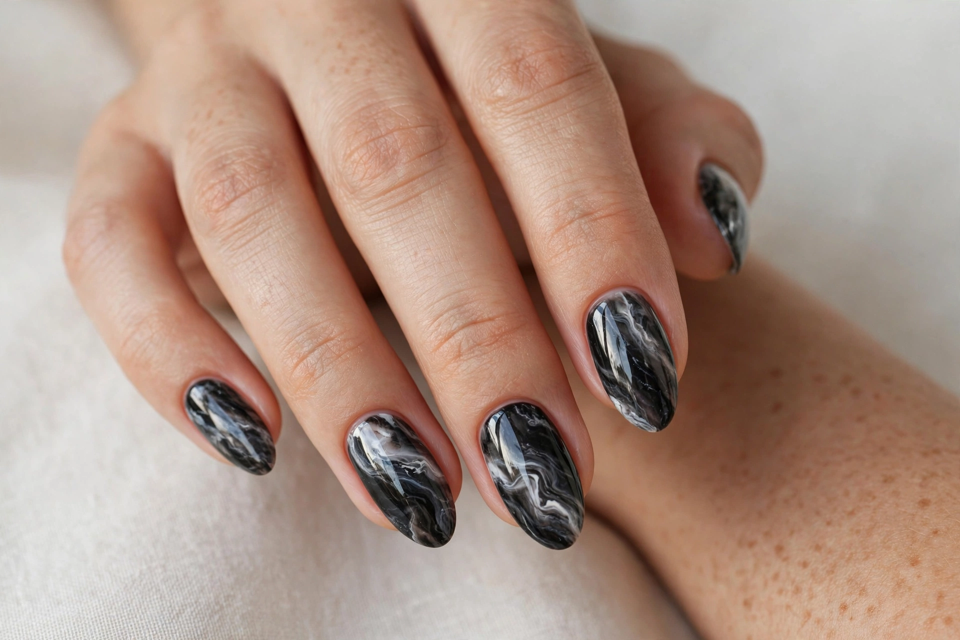 Dark marble swirl nail art in black grey and white like polished stone