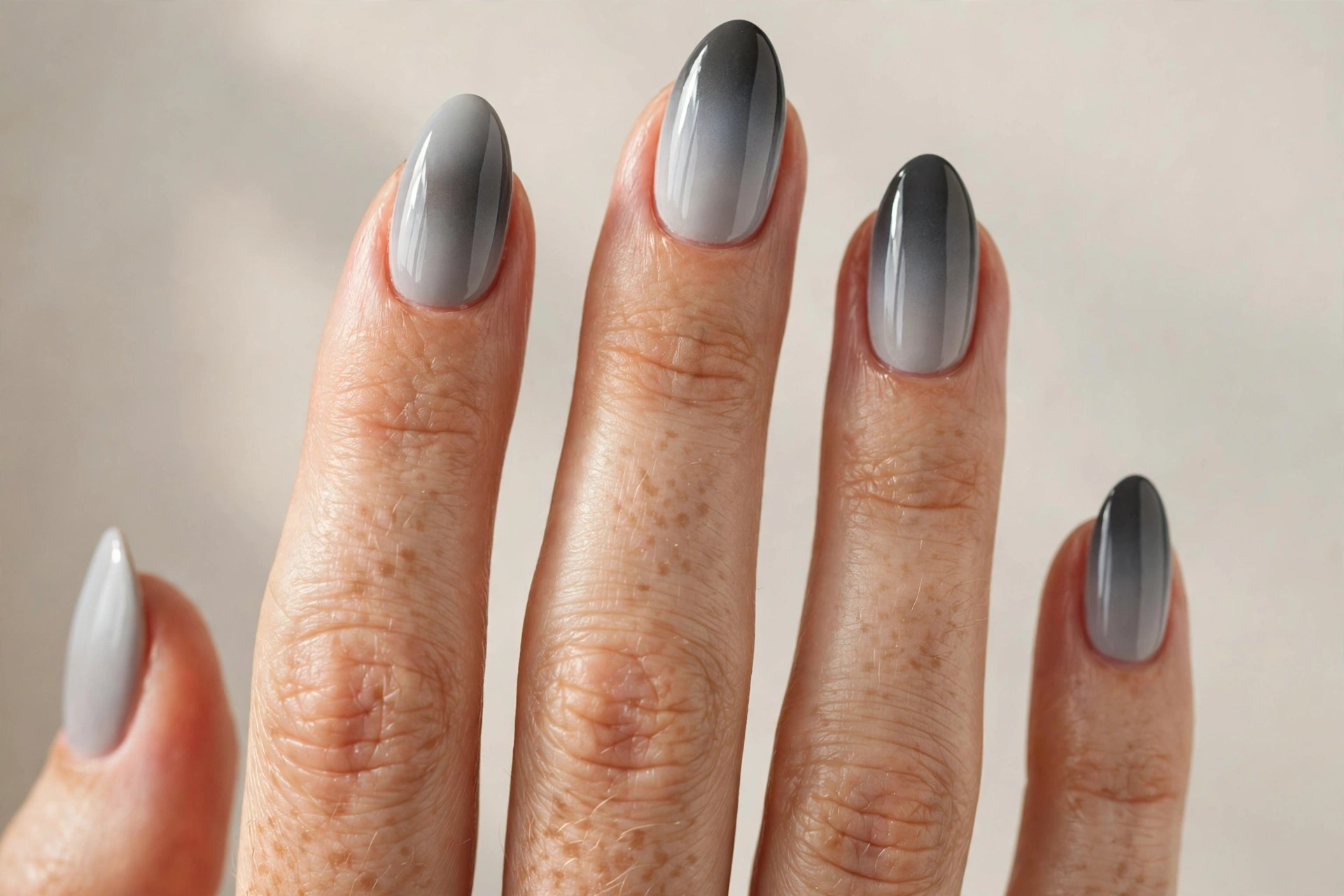 Gray ombre manicure fading from light to dark gray on almond shaped nails