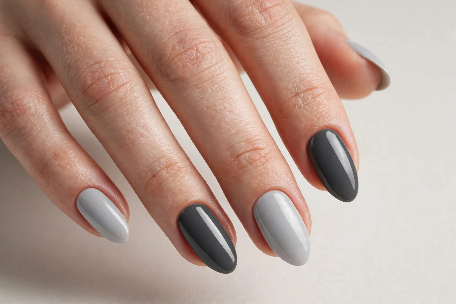 Two-tone gray manicure alternating light and dark gray on almond shaped nails