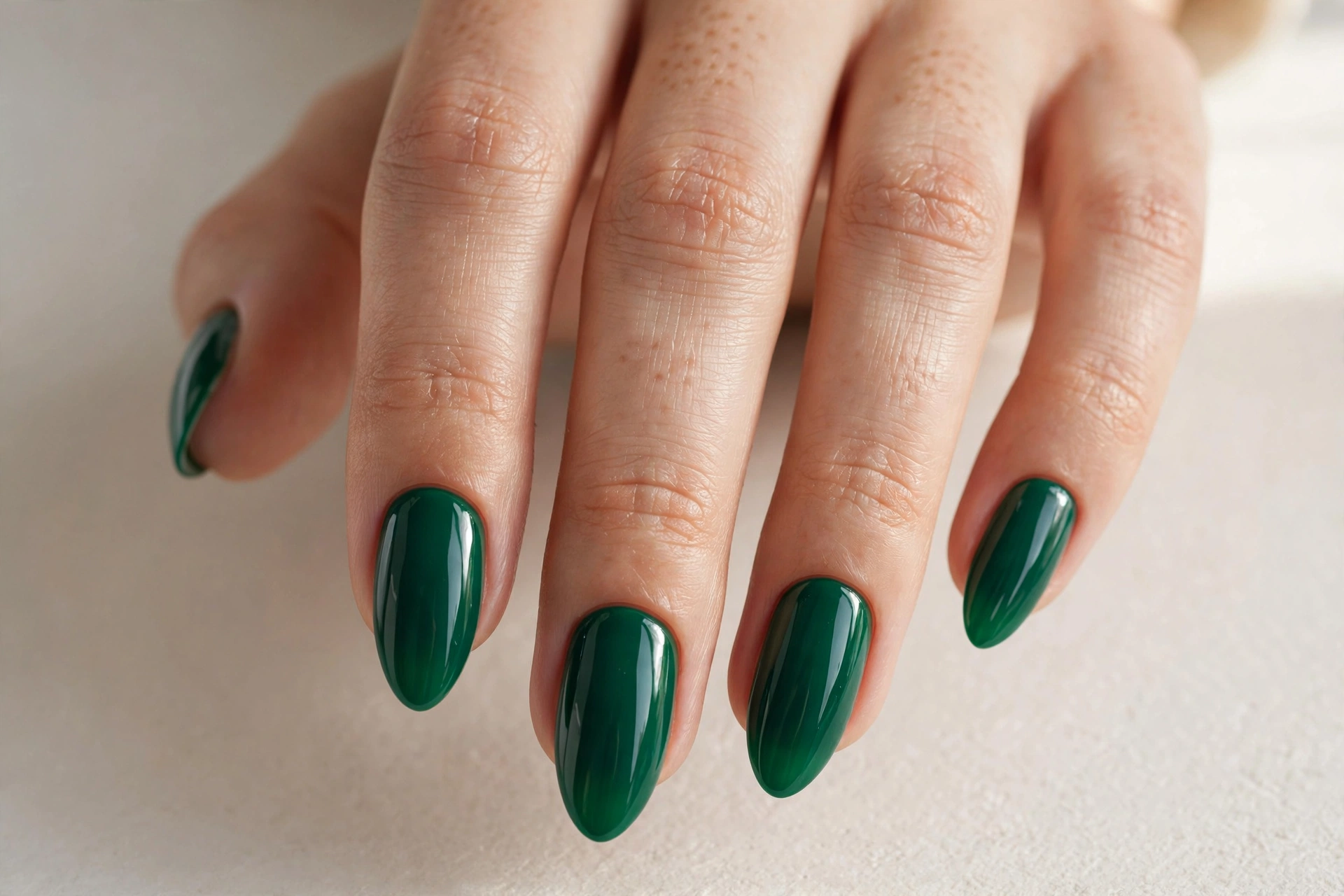 Classic glossy emerald green Christmas nails on almond shaped nails