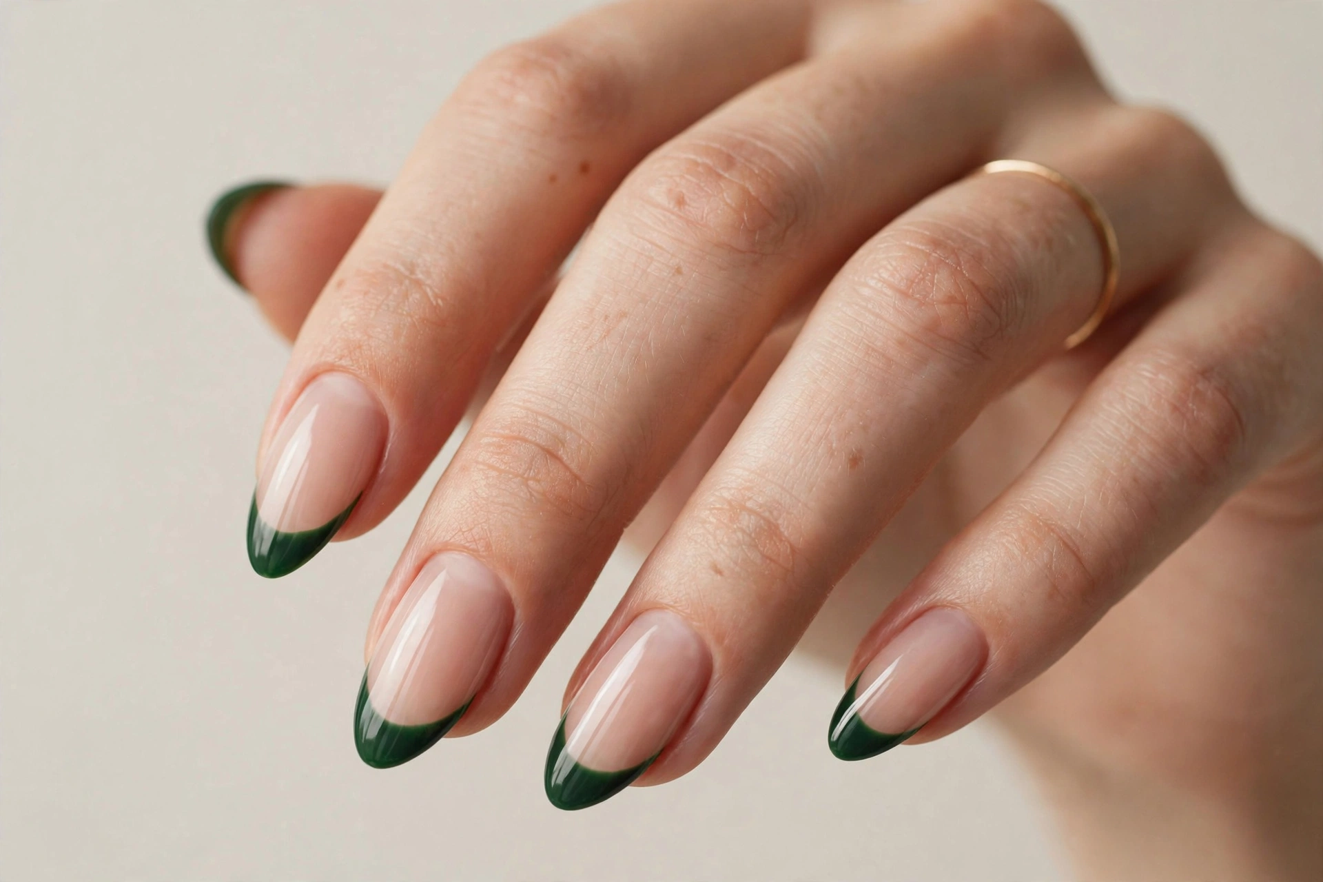 French tip manicure with deep green tips on nude nails
